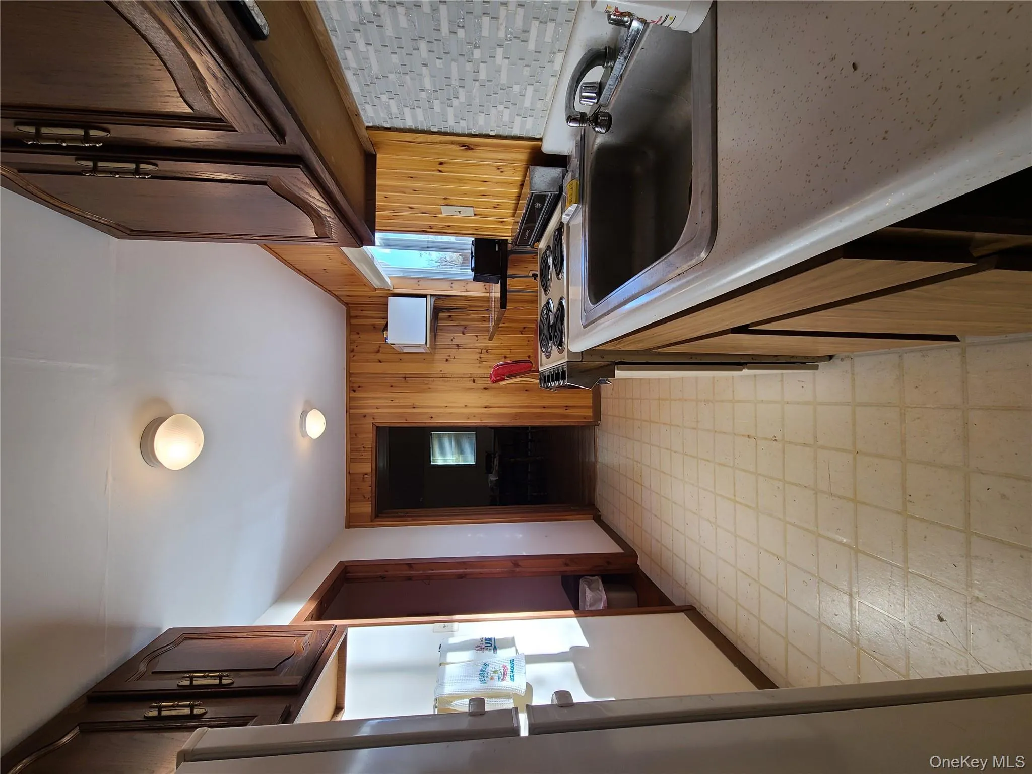 Kitchen with light flooring, stove, fridge, light countertops, and dark brown cabinetry Kitchen with light flooring, stove, fridge, light countertops, and dark brown cabinetry