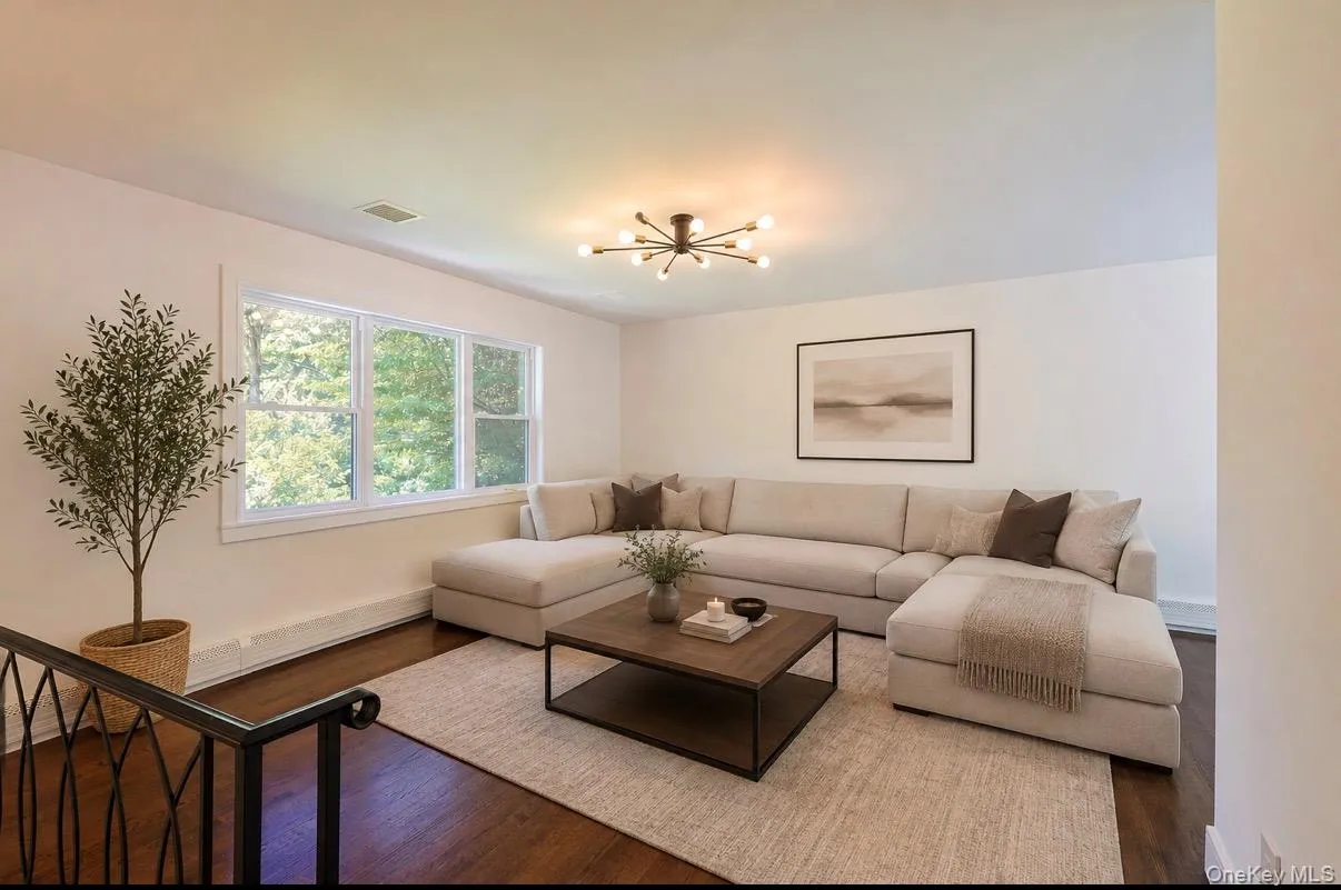 Hardwood flooring, white window trim, contemporary chandelier, white wall finishes, and black wrought iron railing Hardwood flooring, white window trim, contemporary chandelier, white wall finishes, and black wrought iron railing