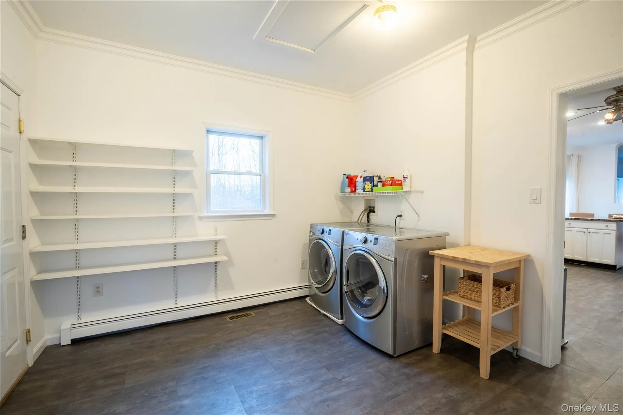 Washroom with laundry area, crown molding, baseboard heating, and washer and dryer Washroom with laundry area, crown molding, baseboard heating, and washer and dryer