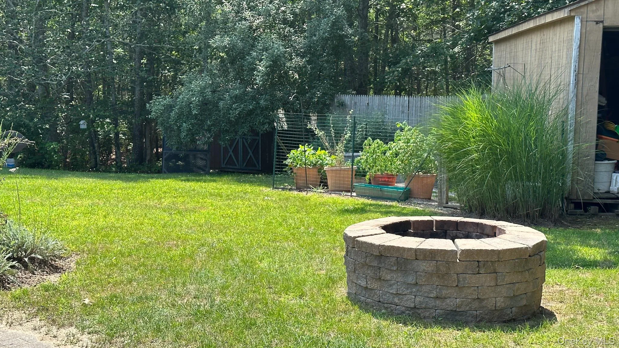 View of yard featuring an outdoor fire pit and fence View of yard featuring an outdoor fire pit and fence