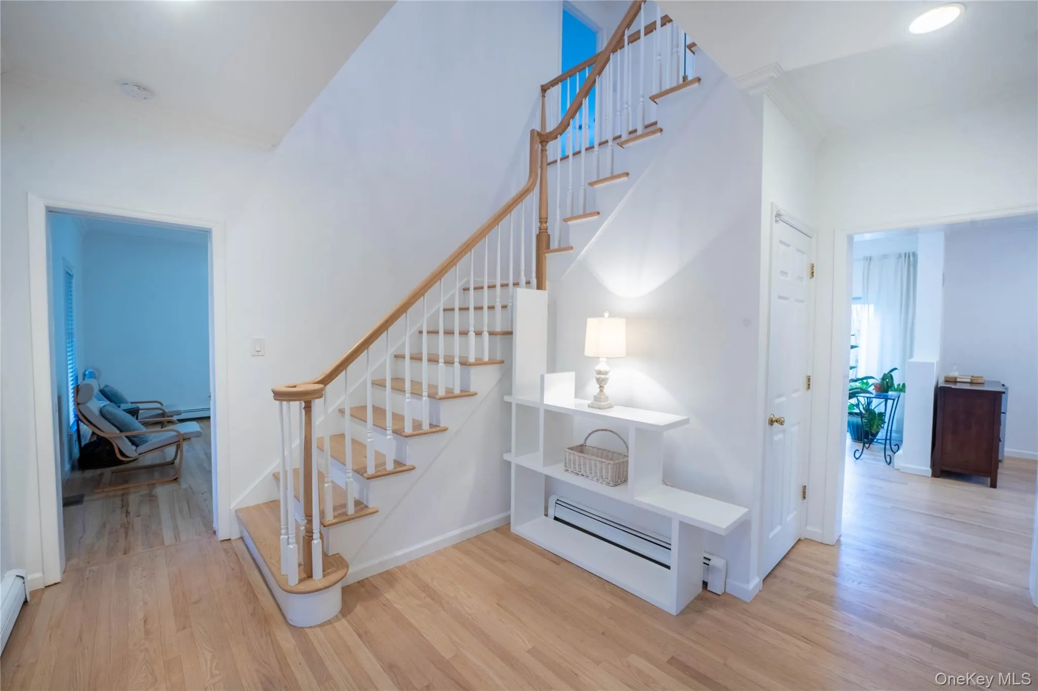 Staircase featuring baseboards, a baseboard heating unit, crown molding, and wood finished floors Staircase featuring baseboards, a baseboard heating unit, crown molding, and wood finished floors