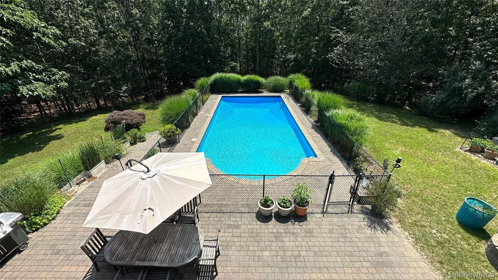 View of pool featuring a fenced in pool, fence, a lawn, and a patio View of pool featuring a fenced in pool, fence, a lawn, and a patio