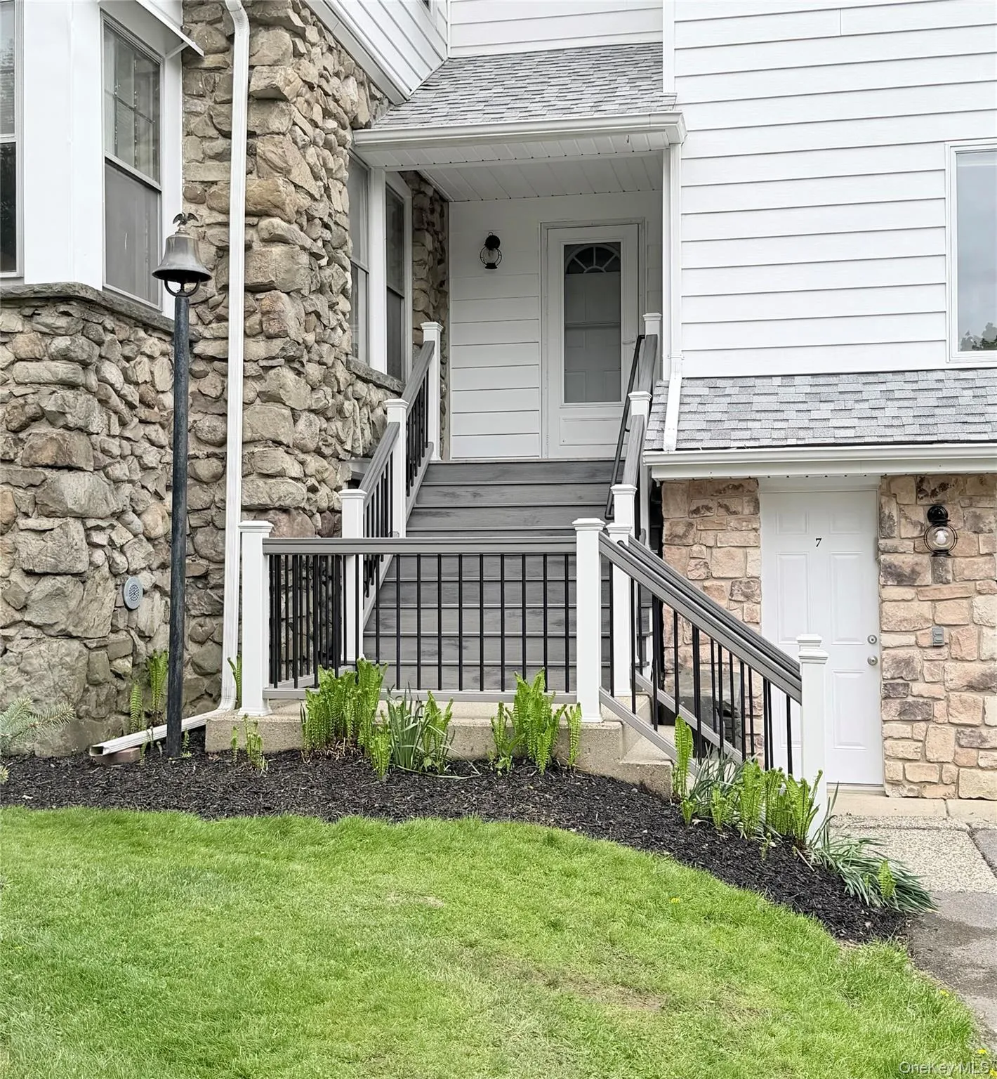 Side entrance of home with Trex staircase and wrought iron railing Side entrance of home with Trex staircase and wrought iron railing