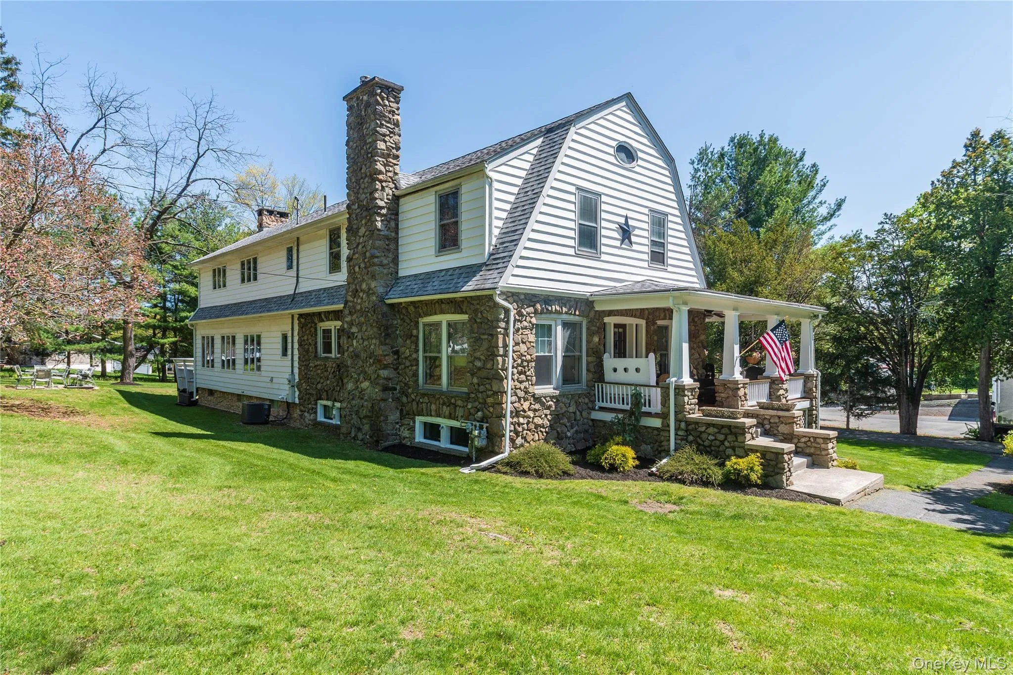 A side view of the home revealing the well-maintained property and stone chimney. A side view of the home revealing the well-maintained property and stone chimney.
