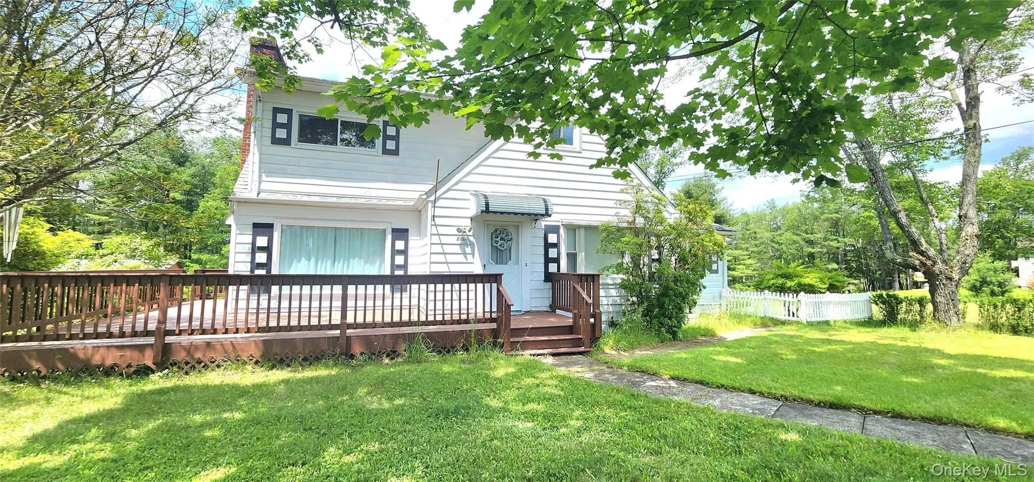 View of front facade featuring a chimney and a deck View of front facade featuring a chimney and a deck