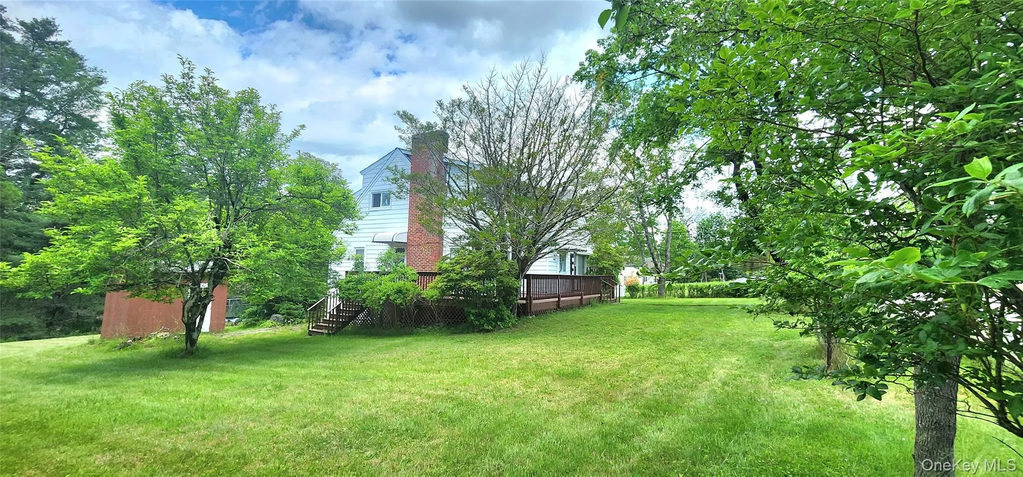 View of grassy yard with a deck and stairway View of grassy yard with a deck and stairway