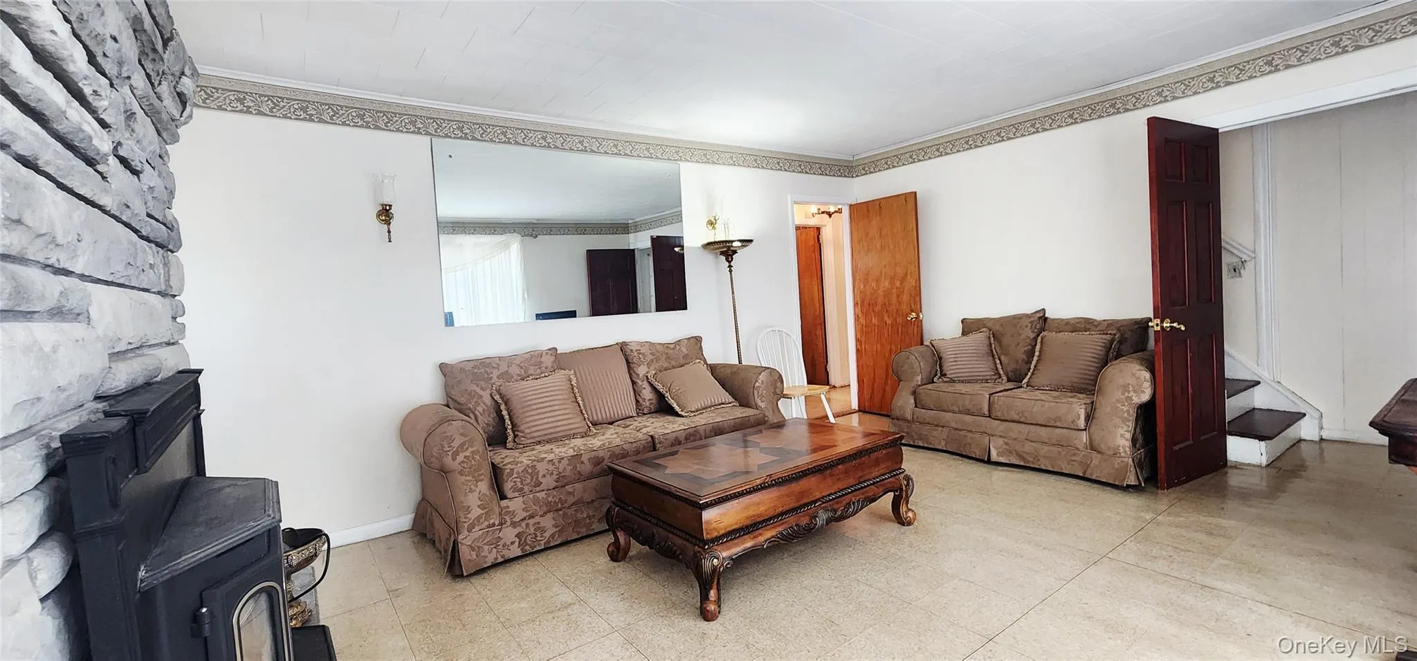 Living area featuring a wood stove and crown molding Living area featuring a wood stove and crown molding
