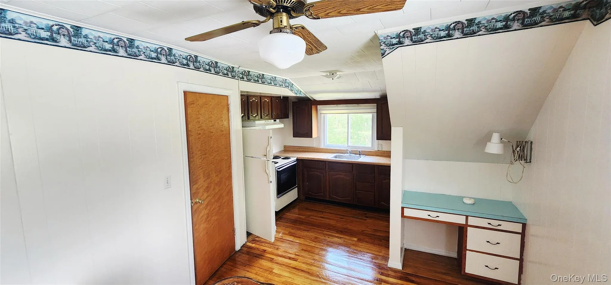 Kitchen featuring white range with electric stovetop, hardwood / wood-style floors, under cabinet range hood, ceiling fan, and light countertops Kitchen featuring white range with electric stovetop, hardwood / wood-style floors, under cabinet range hood, ceiling fan, and light countertops