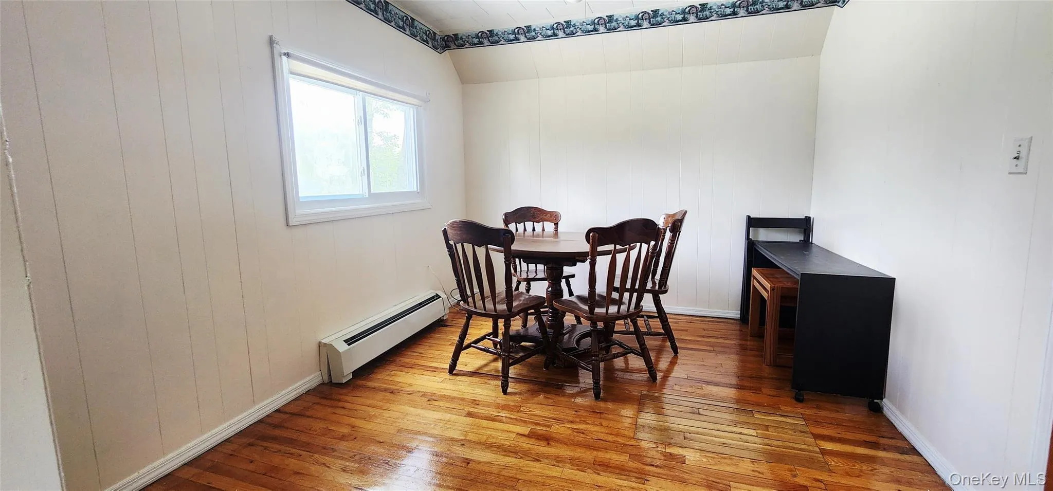 Dining room featuring baseboard heating and wood-type flooring Dining room featuring baseboard heating and wood-type flooring