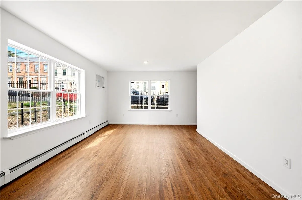 Empty room featuring baseboard heating and light wood-style flooring Empty room featuring baseboard heating and light wood-style flooring