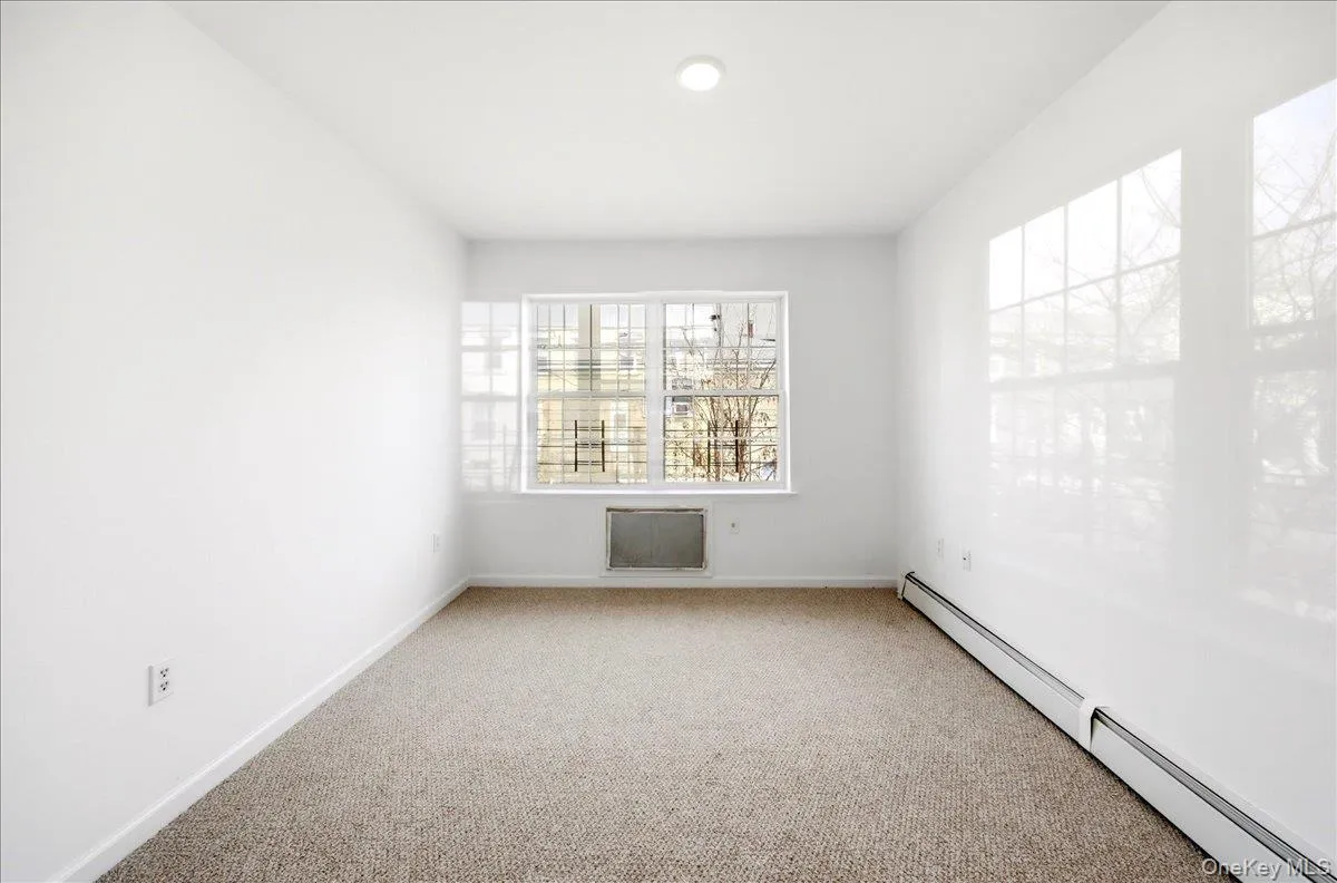 Carpeted spare room with a baseboard heating unit and baseboards Carpeted spare room with a baseboard heating unit and baseboards