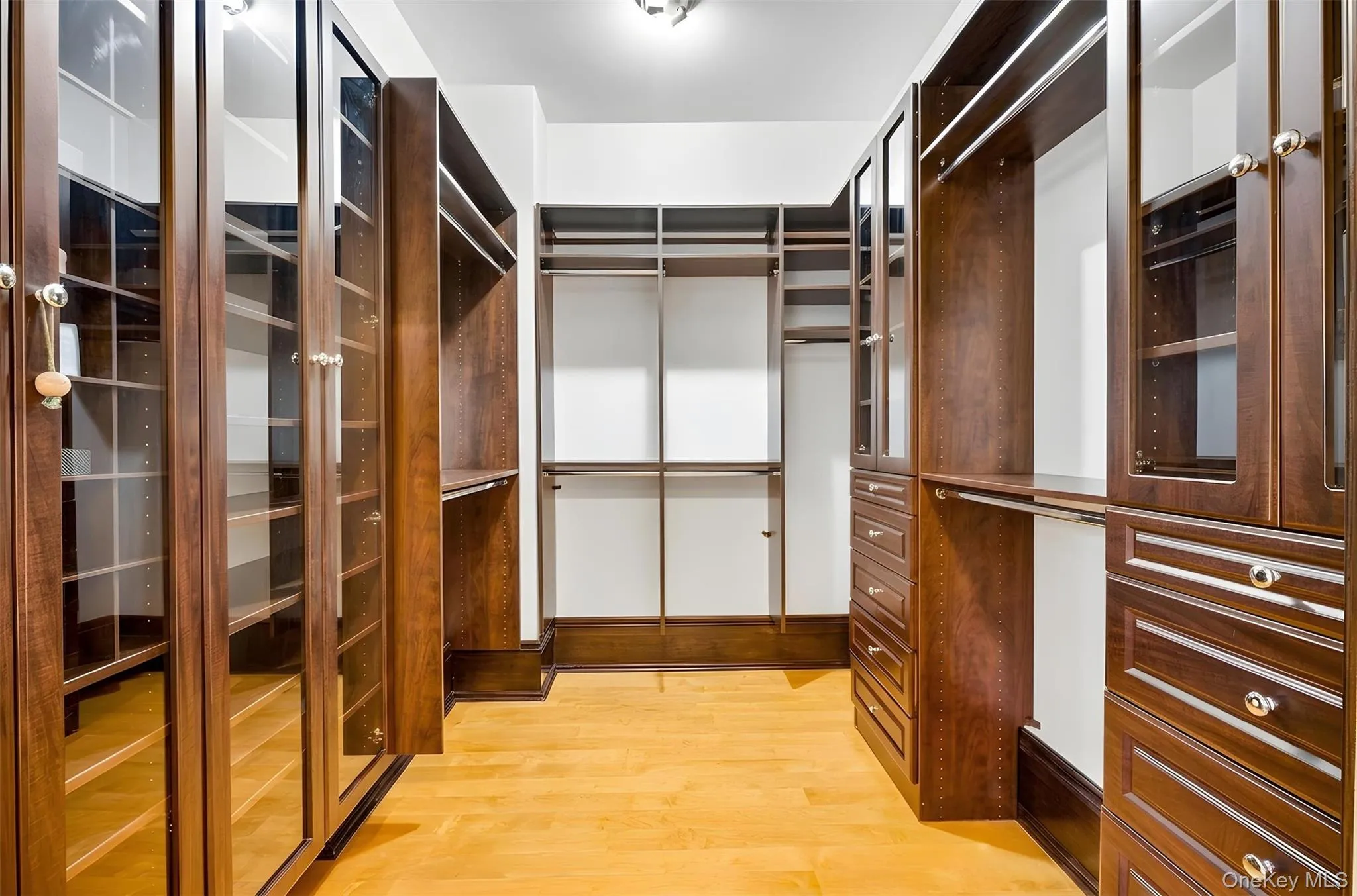 Walk in closet with light wood finished floors Walk in closet with light wood finished floors