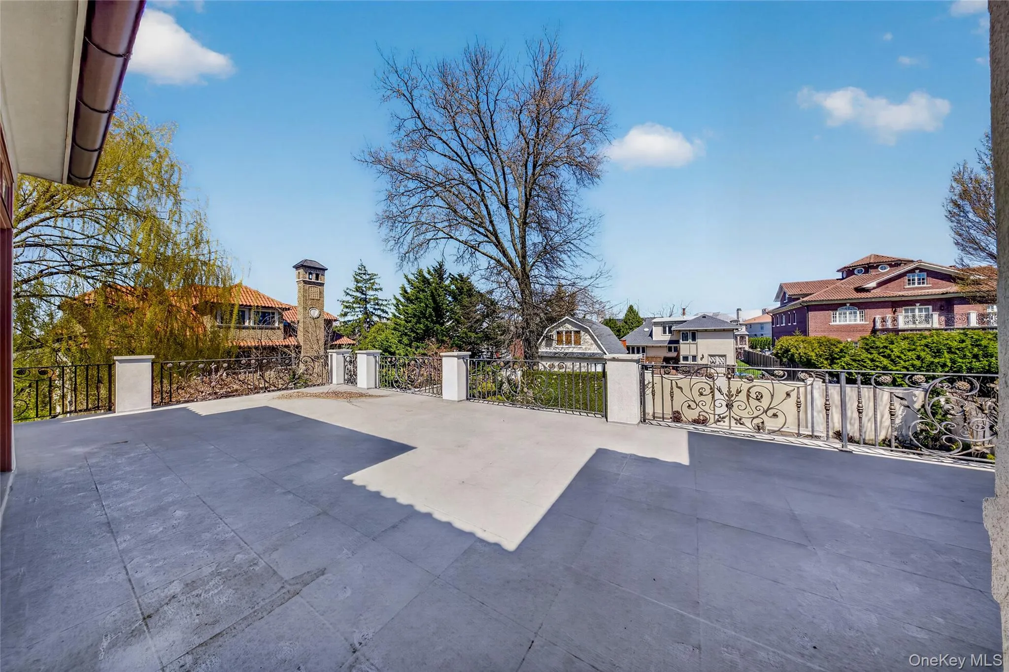 View of patio with a residential view and a gate View of patio with a residential view and a gate