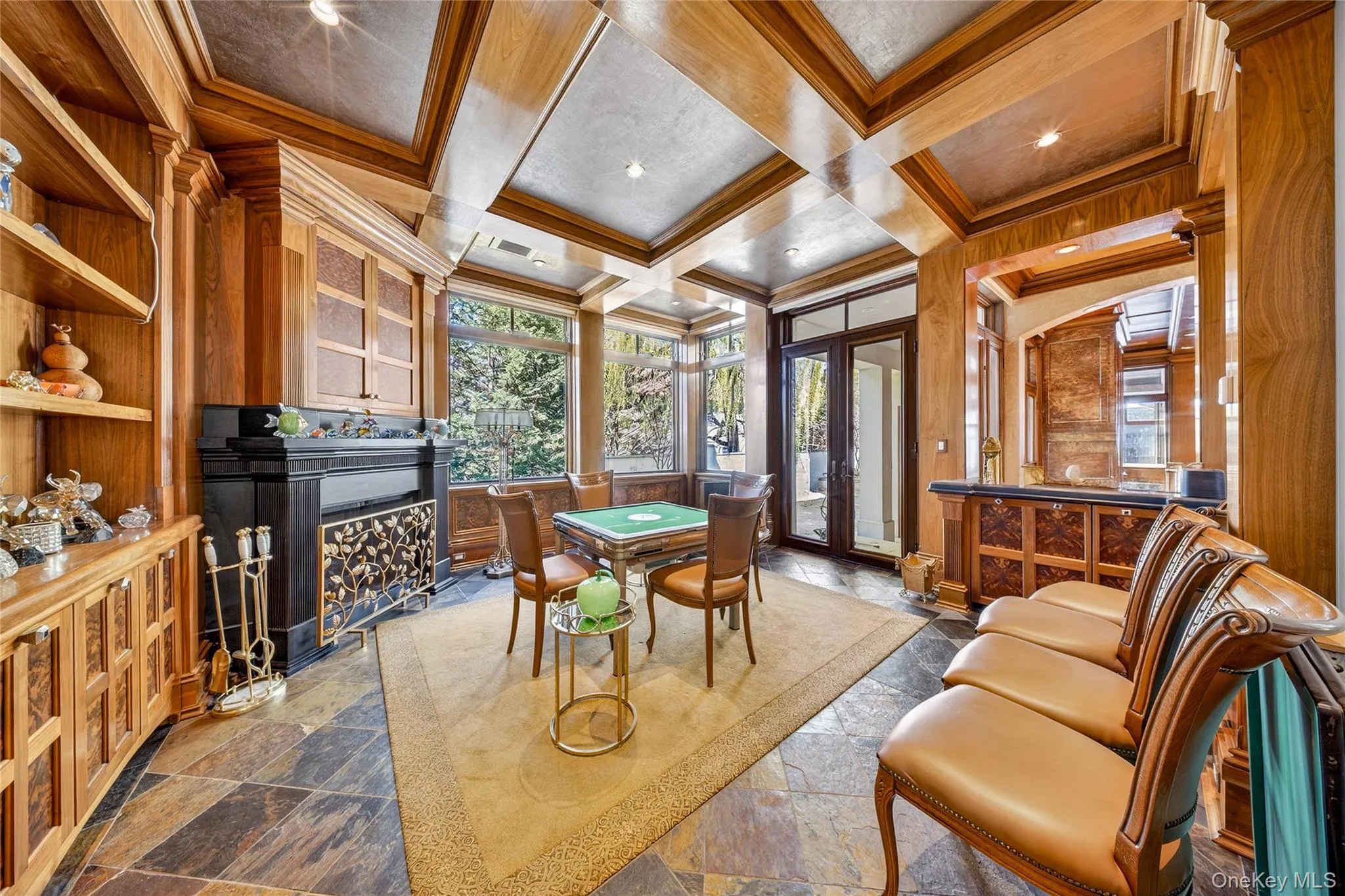 Home office featuring coffered ceiling, a fireplace, healthy amount of natural light, ornamental molding, and stone finish floors Home office featuring coffered ceiling, a fireplace, healthy amount of natural light, ornamental molding, and stone finish floors