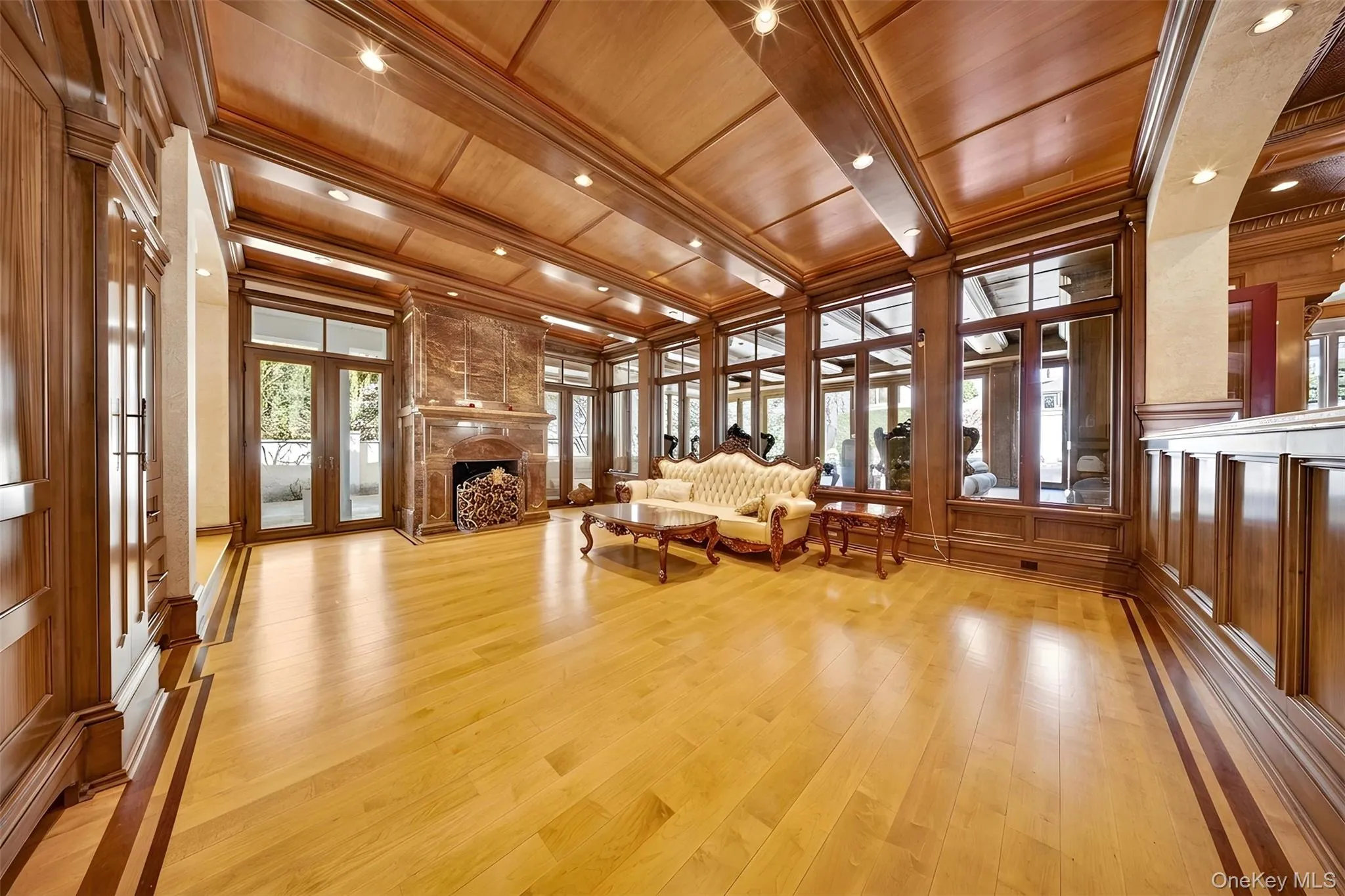 Living area featuring wooden ceiling, french doors, light wood-style floors, a fireplace, and a decorative wall Living area featuring wooden ceiling, french doors, light wood-style floors, a fireplace, and a decorative wall