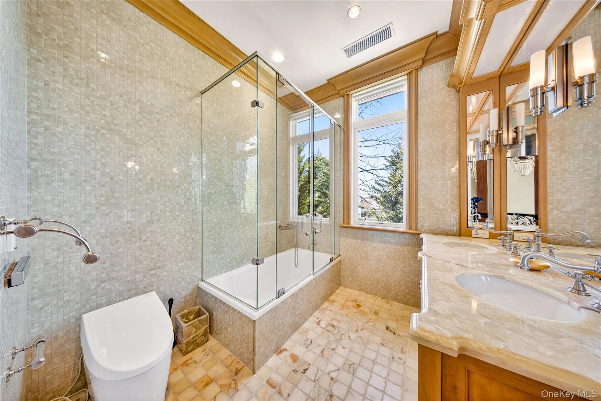 Full bath featuring double vanity, tiled shower / bath, and tile walls Full bath featuring double vanity, tiled shower / bath, and tile walls