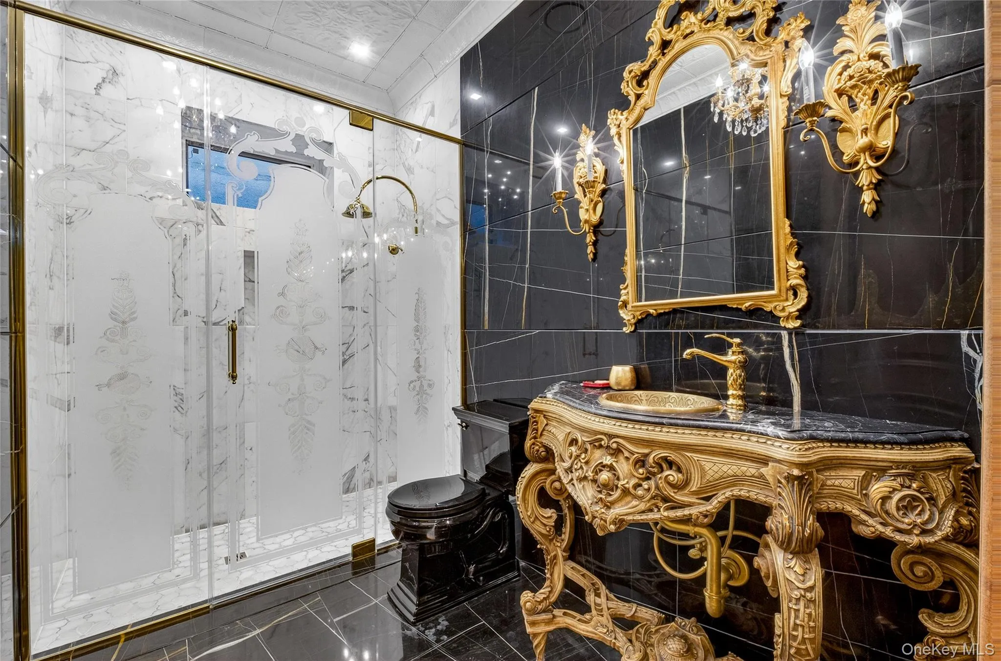 Bathroom featuring tile walls, a marble finish shower, and vanity Bathroom featuring tile walls, a marble finish shower, and vanity