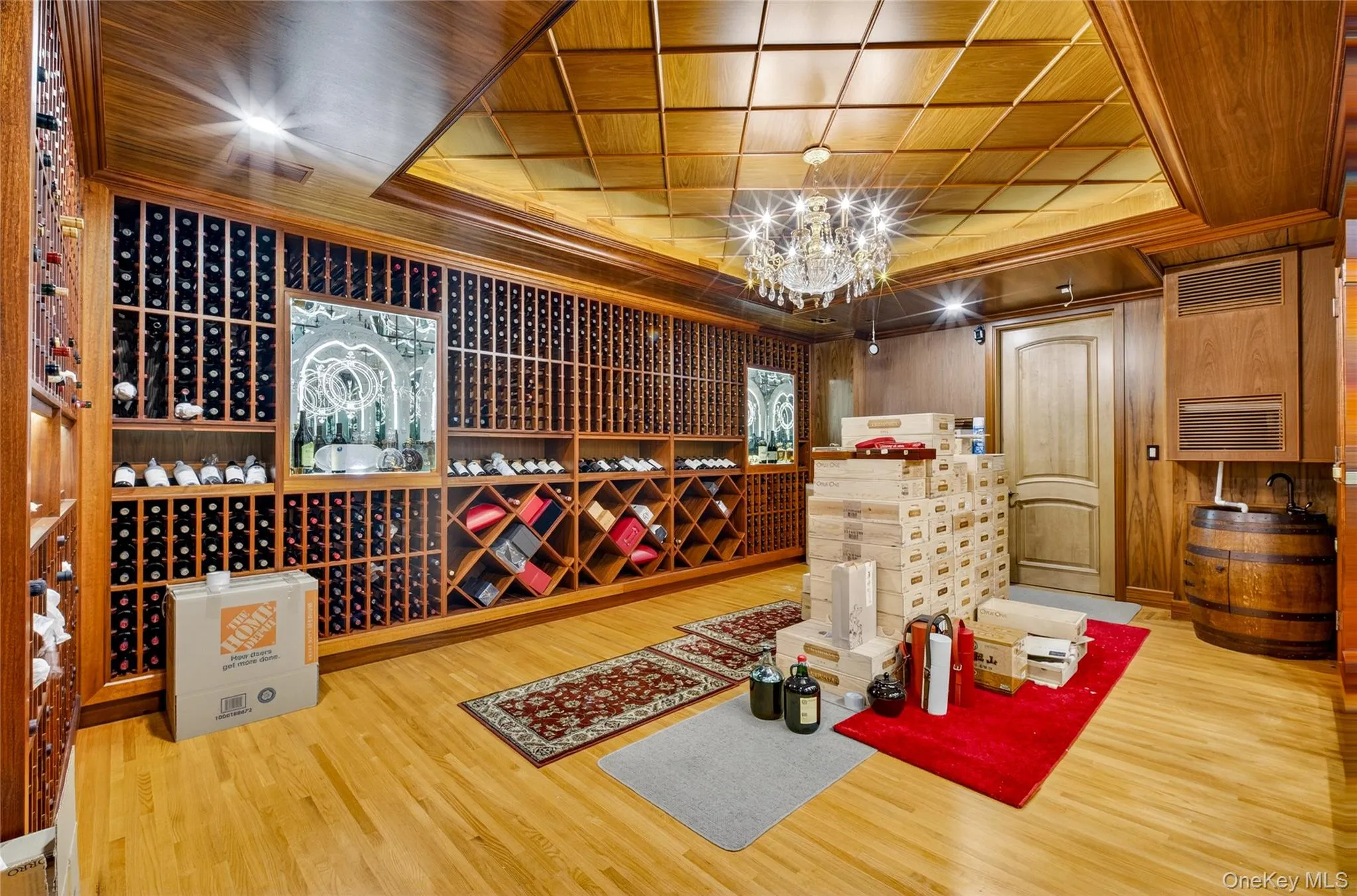 Wine room featuring a chandelier, light wood-style flooring, wood walls, and a wooden tray ceiling Wine room featuring a chandelier, light wood-style flooring, wood walls, and a wooden tray ceiling