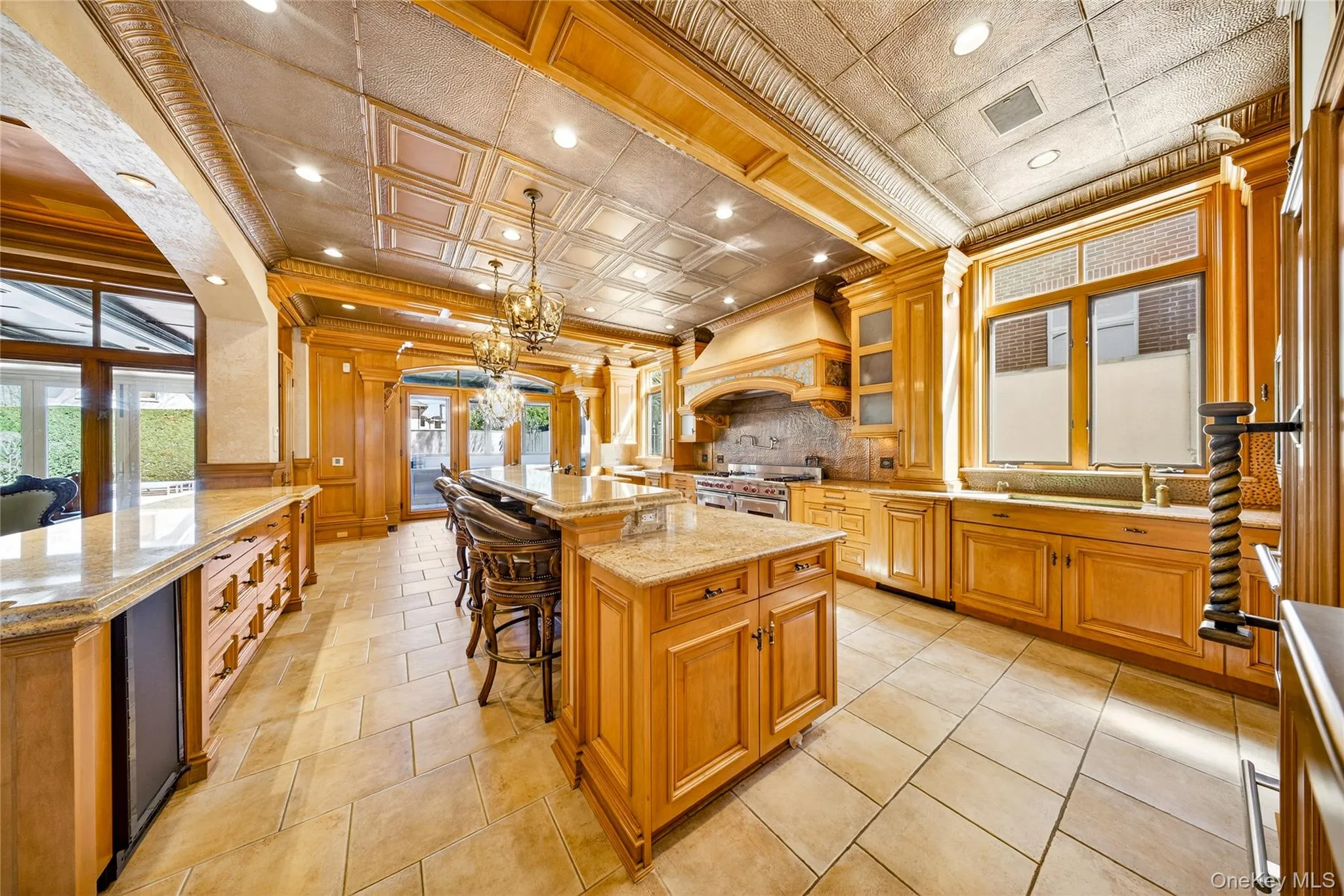Kitchen with a breakfast bar, ornamental molding, light stone counters, tasteful backsplash, and glass insert cabinets Kitchen with a breakfast bar, ornamental molding, light stone counters, tasteful backsplash, and glass insert cabinets