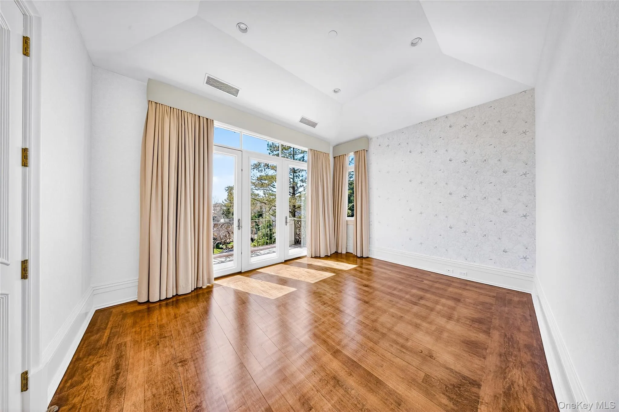Spare room featuring wallpapered walls, wood finished floors, vaulted ceiling, and recessed lighting Spare room featuring wallpapered walls, wood finished floors, vaulted ceiling, and recessed lighting