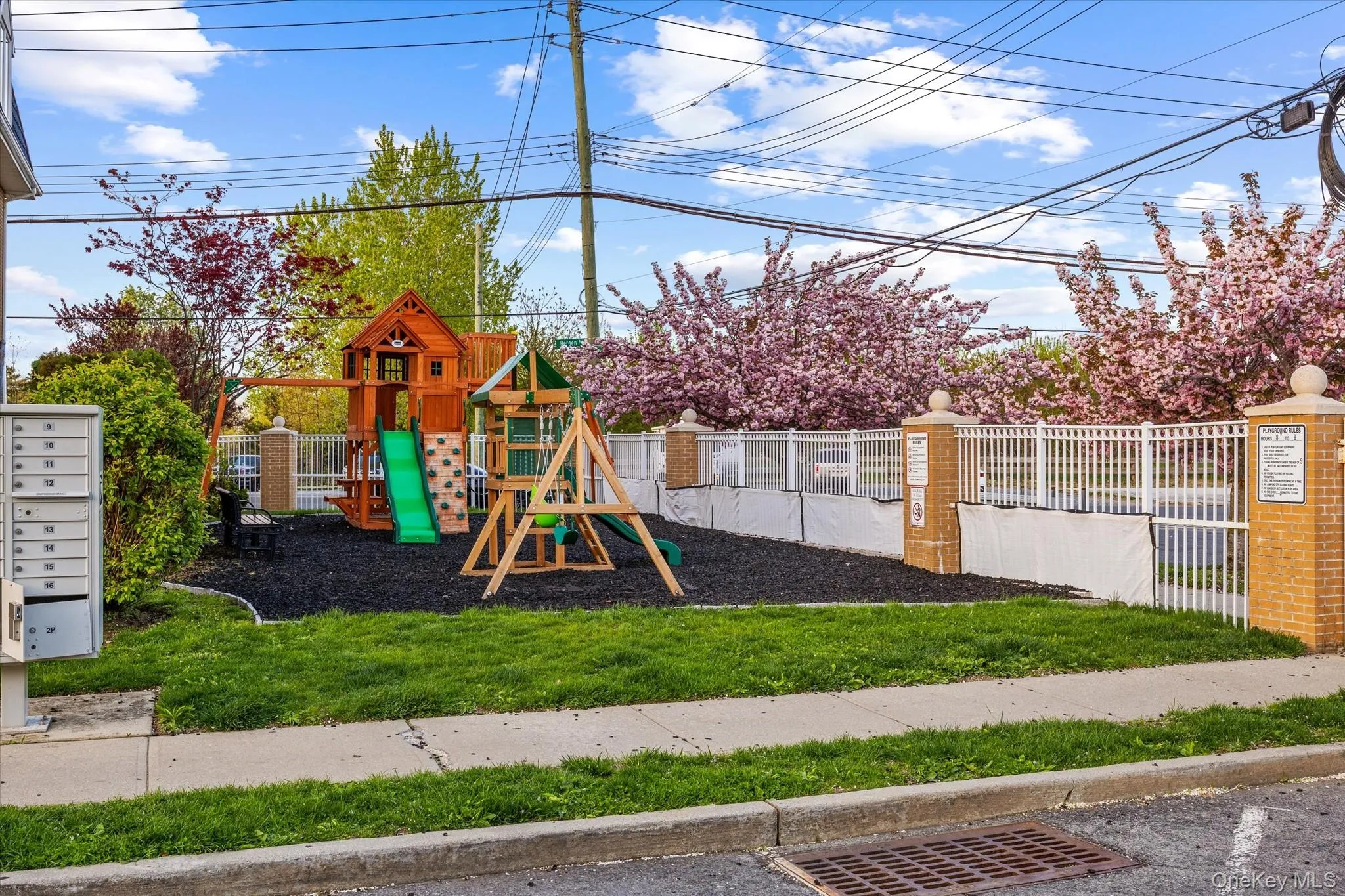 Outdoor play area for small kids featuring a multi-level playset with slides, swings, and rock climbing wall Outdoor play area for small kids featuring a multi-level playset with slides, swings, and rock climbing wall