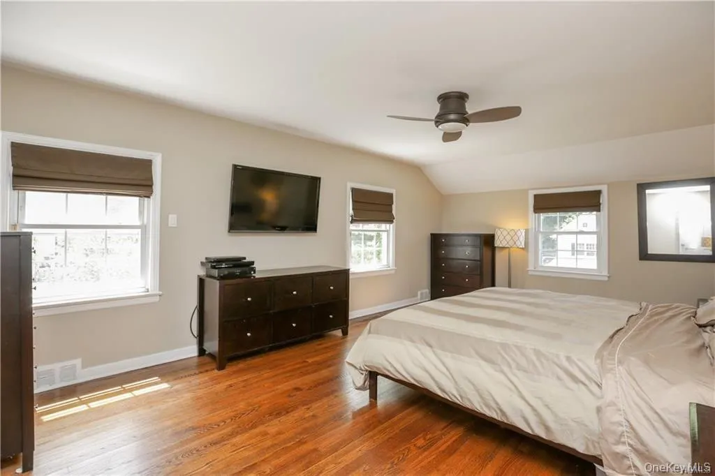 Primary bedroom with beautiful hardwood floors, walls of windows that allow for tons of natural light with ensuite primary bath. Primary bedroom with beautiful hardwood floors, walls of windows that allow for tons of natural light with ensuite primary bath.