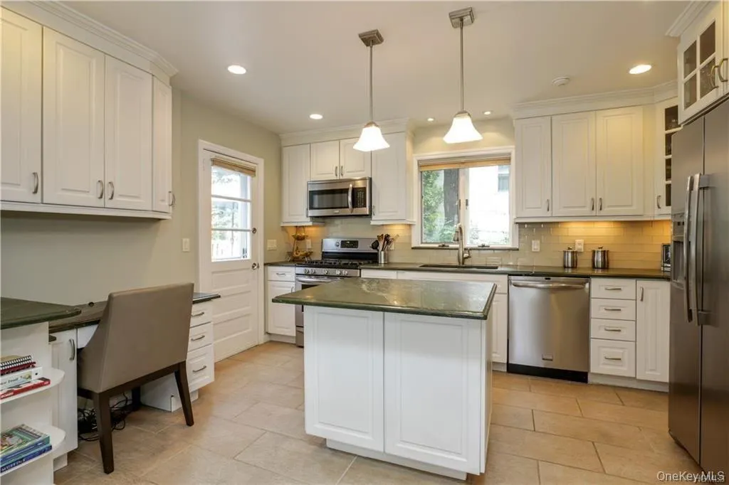 Fabulous chef's kitchen with gorgeous granite counter tops. High end appliances, built in microwave, built in desk with bookshelves with a door that leads to the generously sized deck for enjoying a summer evening outside! Fabulous chef's kitchen with gorgeous granite counter tops. High end appliances, built in microwave, built in desk with bookshelves with a door that leads to the generously sized deck for enjoying a summer evening outside!