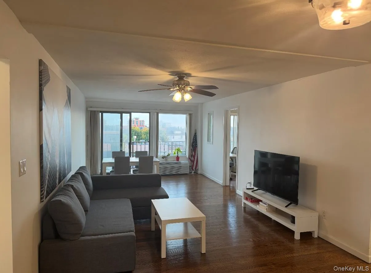 Living area featuring dark wood-style floors and a ceiling fan Living area featuring dark wood-style floors and a ceiling fan