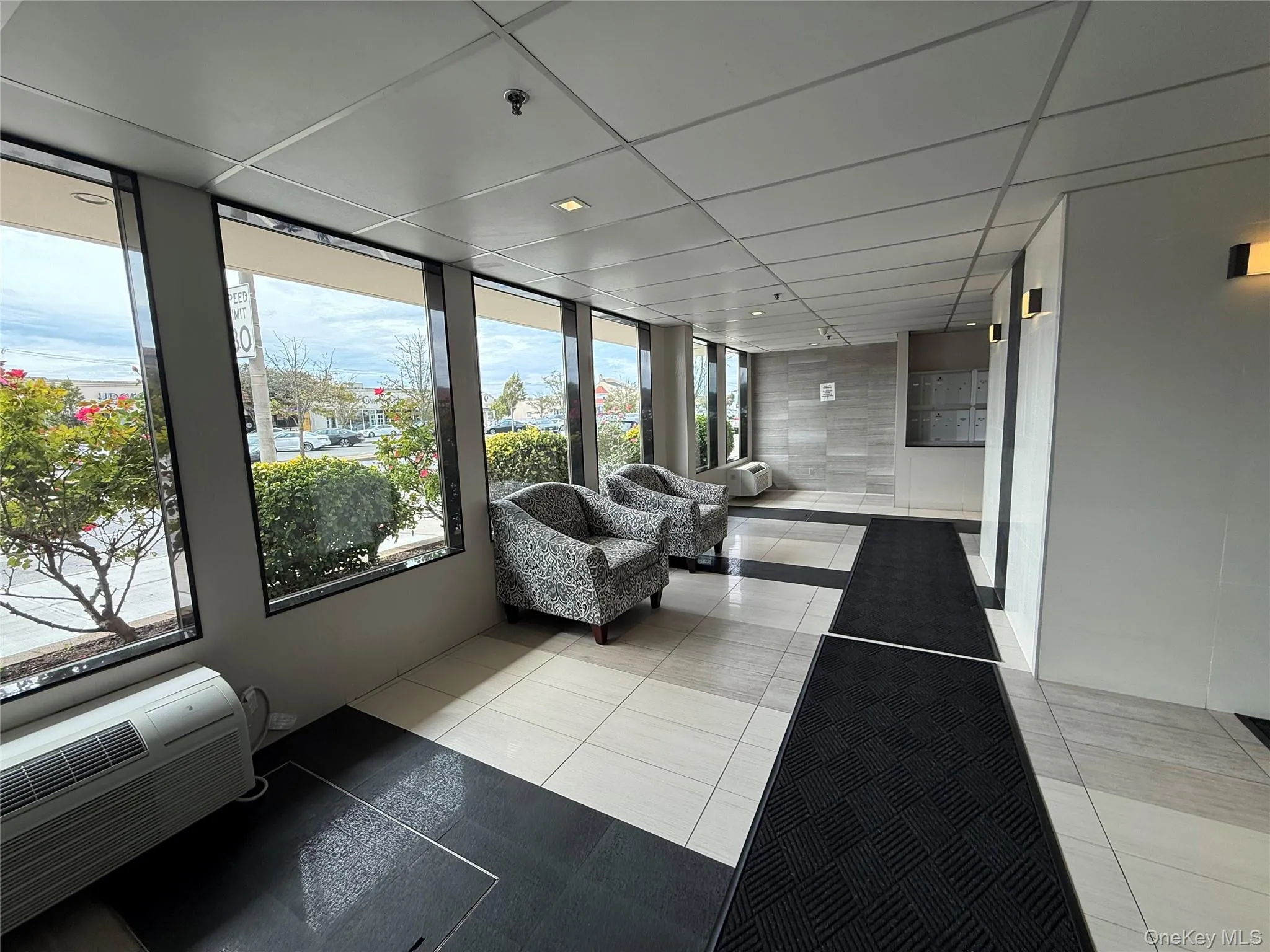 Sunroom / solarium with a drop ceiling, tile patterned flooring, cooling unit, and a wall mounted air conditioner Sunroom / solarium with a drop ceiling, tile patterned flooring, cooling unit, and a wall mounted air conditioner