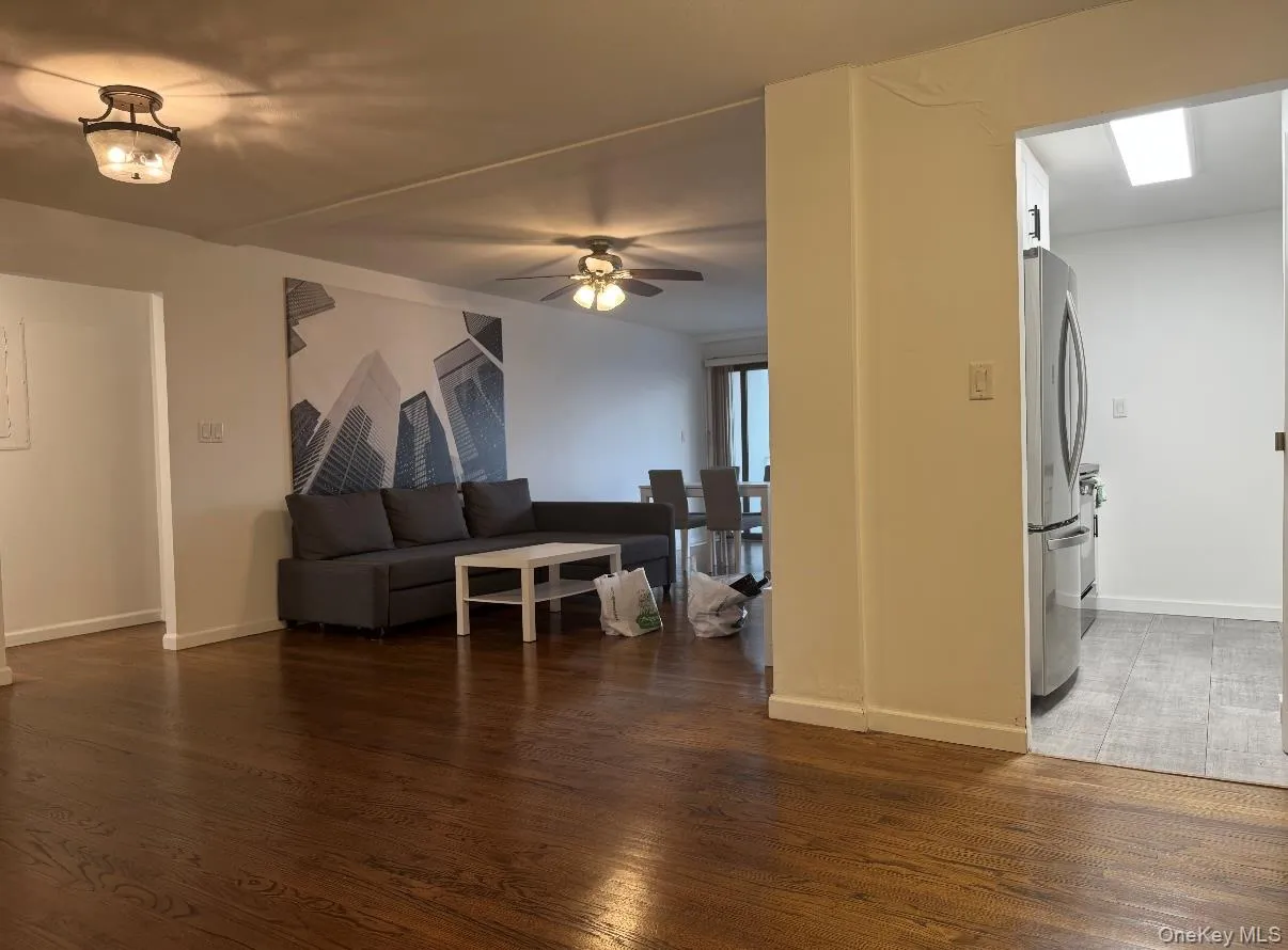 Living room with dark wood-type flooring and a ceiling fan Living room with dark wood-type flooring and a ceiling fan