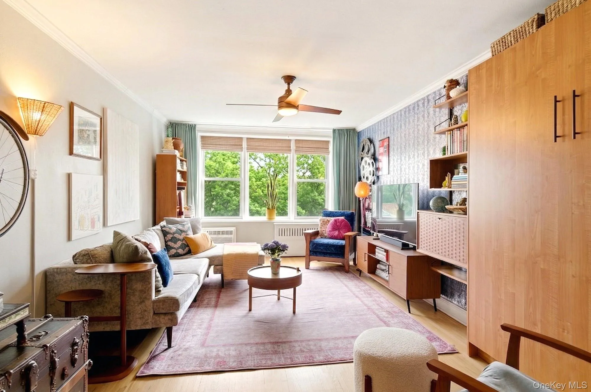 Large living room with a triple window and hardwood floors Large living room with a triple window and hardwood floors