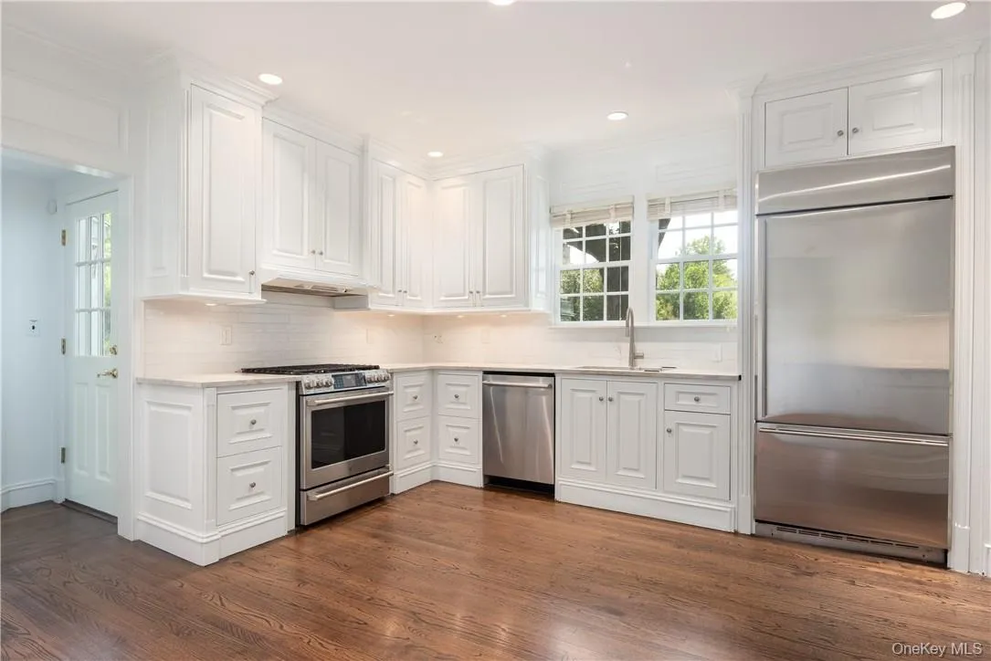 White kitchen features new quartz counter tops, sink and backsplash. White kitchen features new quartz counter tops, sink and backsplash.