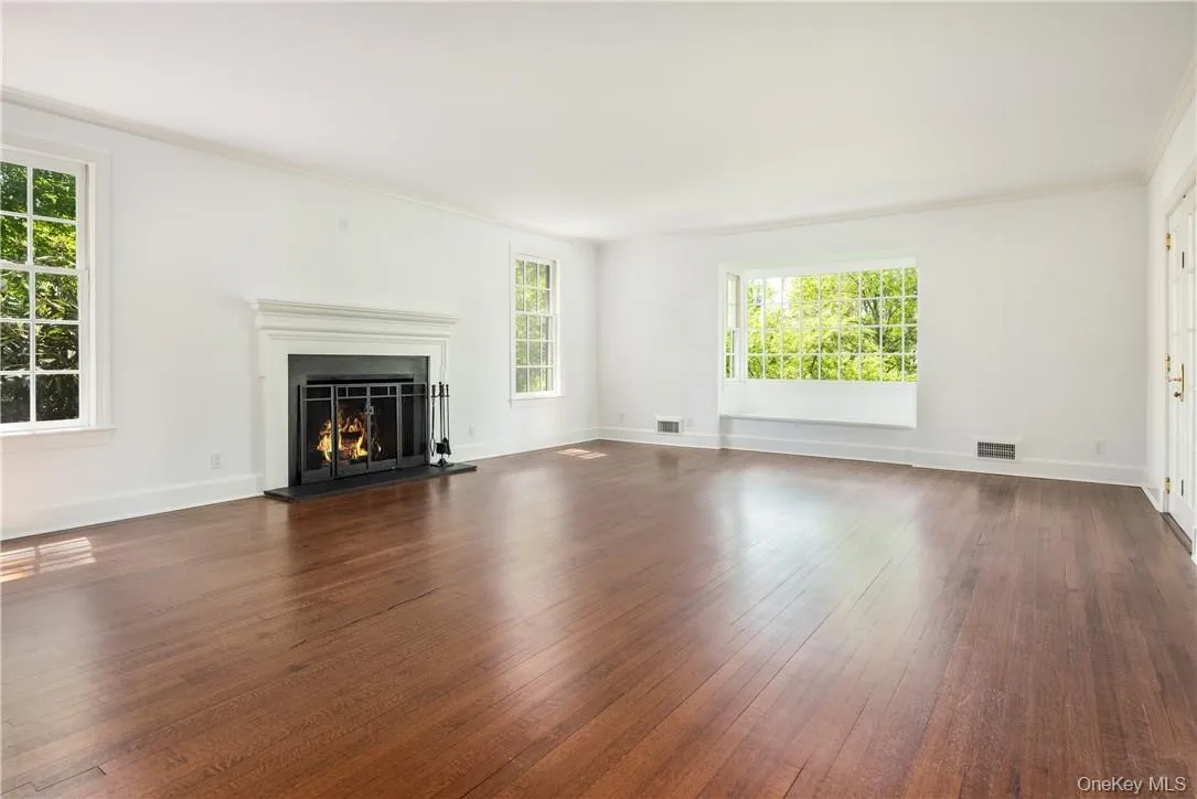 Spacious living room features woodburning fireplace and picture window. Spacious living room features woodburning fireplace and picture window.
