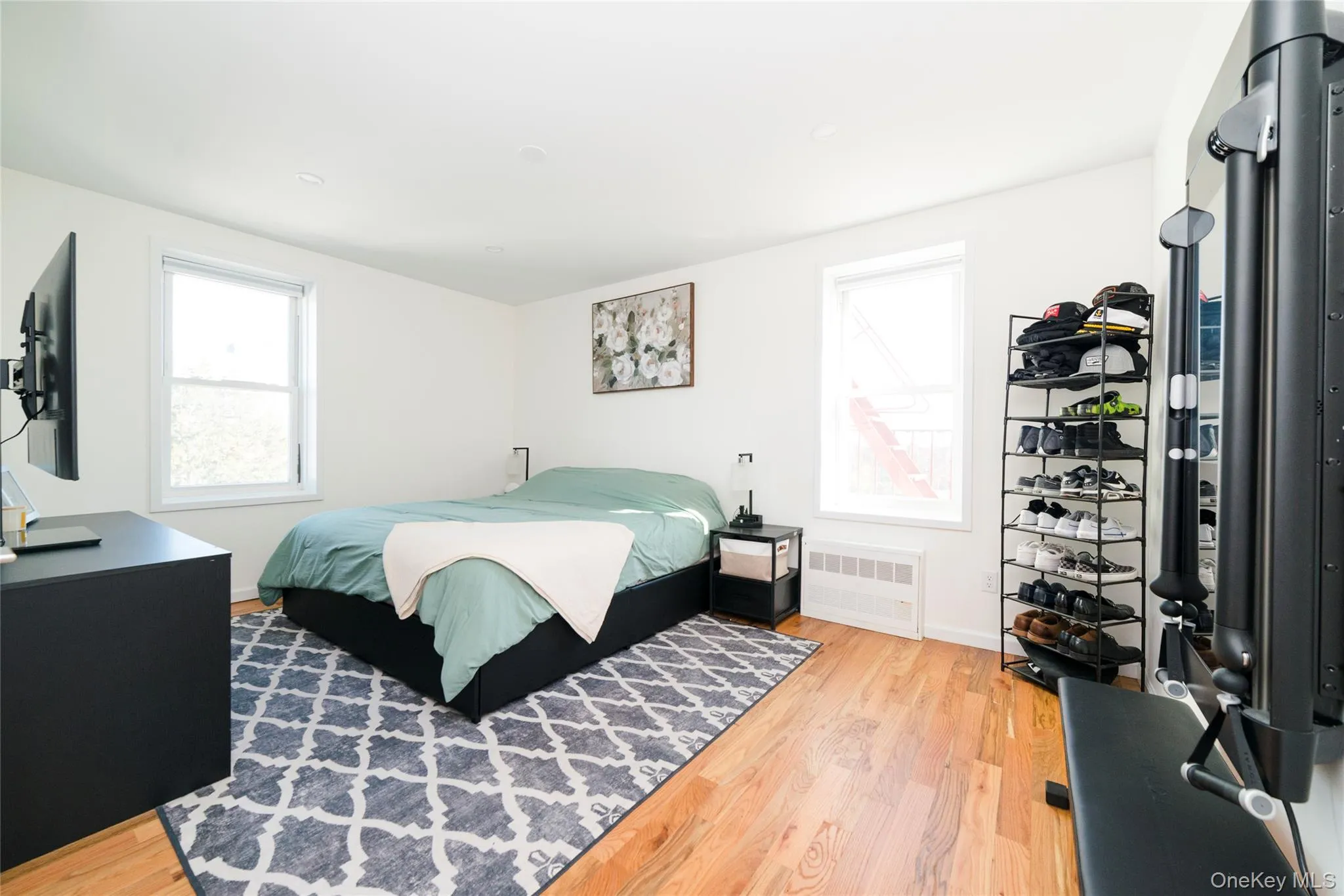 This primary bedroom features king-sized accommodations, hardwood floors, recessed lighting, white walls, and views of the Sound. This primary bedroom features king-sized accommodations, hardwood floors, recessed lighting, white walls, and views of the Sound.