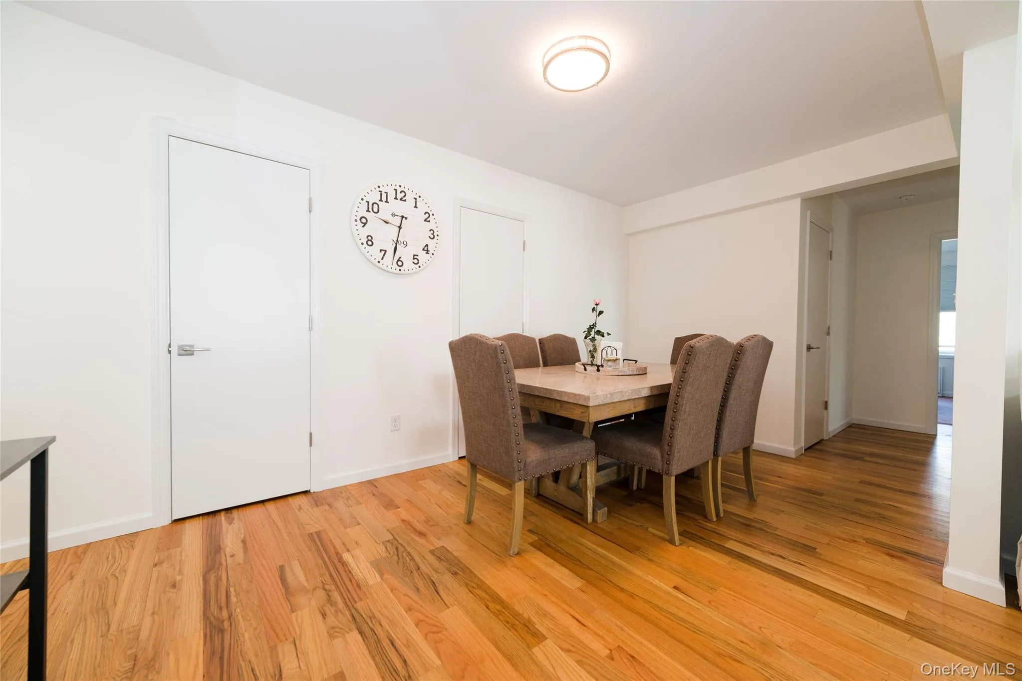Dining area featuring hardwood floors, two closets, and a ceiling light fixture Dining area featuring hardwood floors, two closets, and a ceiling light fixture
