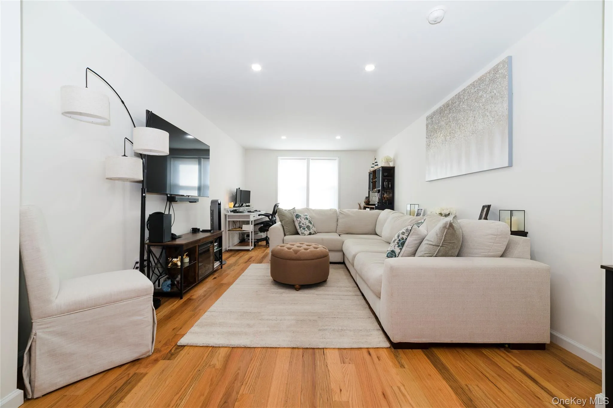 This inviting living space features hardwood floors, recessed lighting, and a neutral color palette This inviting living space features hardwood floors, recessed lighting, and a neutral color palette