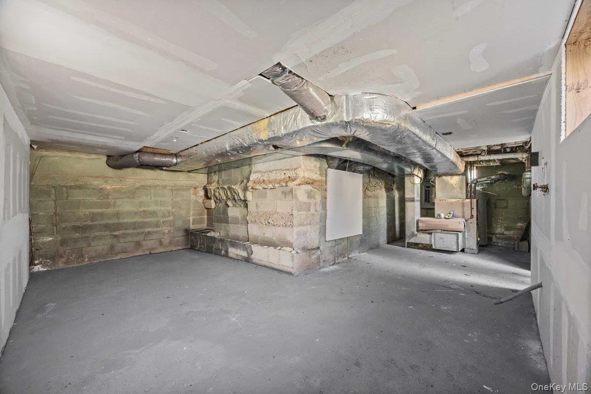 Unfinished basement featuring a concrete floor, exposed block walls, and visible ductwork Unfinished basement featuring a concrete floor, exposed block walls, and visible ductwork