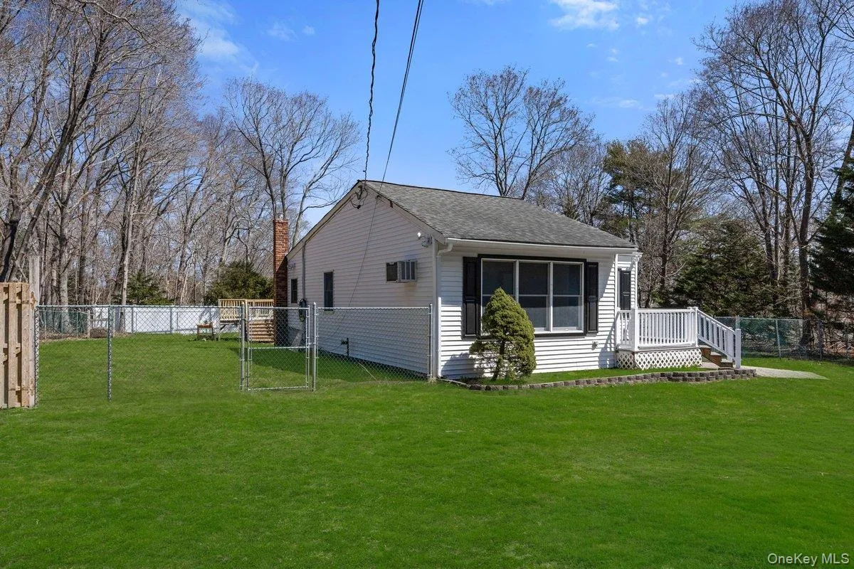 The property features a white exterior with black shutters and a front porch The property features a white exterior with black shutters and a front porch