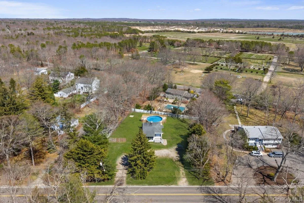 The property features a circular above-ground pool, a well-maintained lawn, and mature trees, all situated within a residential area surrounded by expansive wooded areas The property features a circular above-ground pool, a well-maintained lawn, and mature trees, all situated within a residential area surrounded by expansive wooded areas