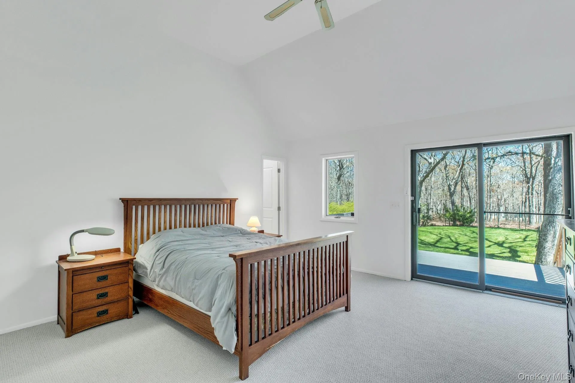 Vaulted ceiling room featuring light gray carpet flooring and white walls Vaulted ceiling room featuring light gray carpet flooring and white walls