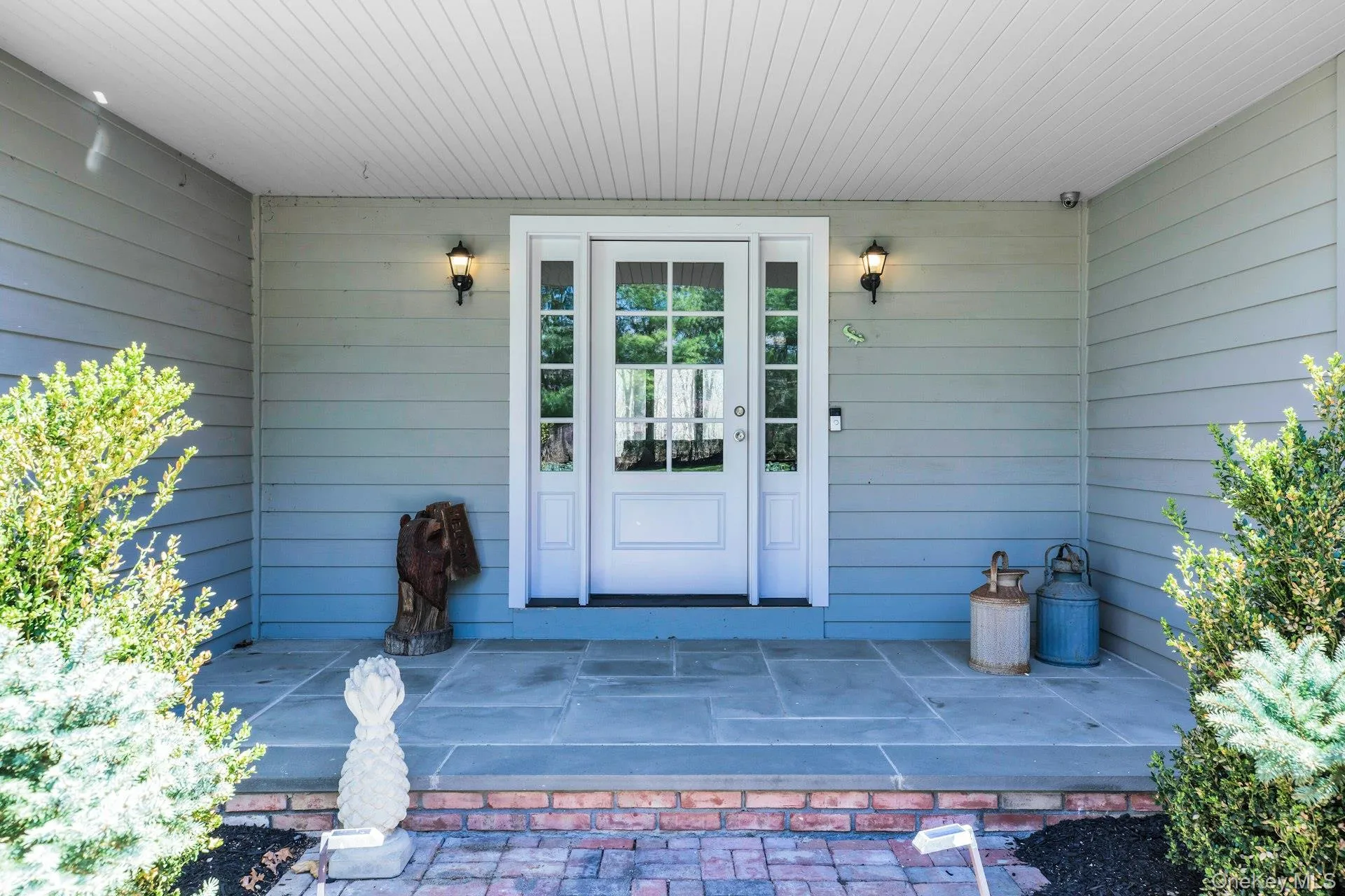 Inviting covered front entry featuring a double glass-panel door, sidelights, and overhead lighting Inviting covered front entry featuring a double glass-panel door, sidelights, and overhead lighting