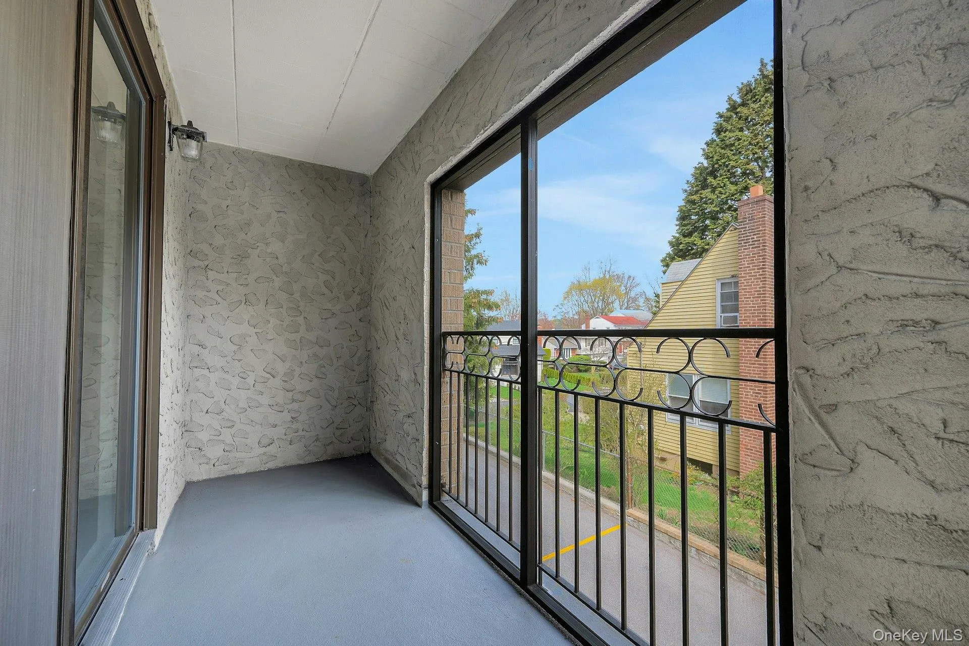 The property includes a private balcony with a view of mature trees and a residential street The property includes a private balcony with a view of mature trees and a residential street