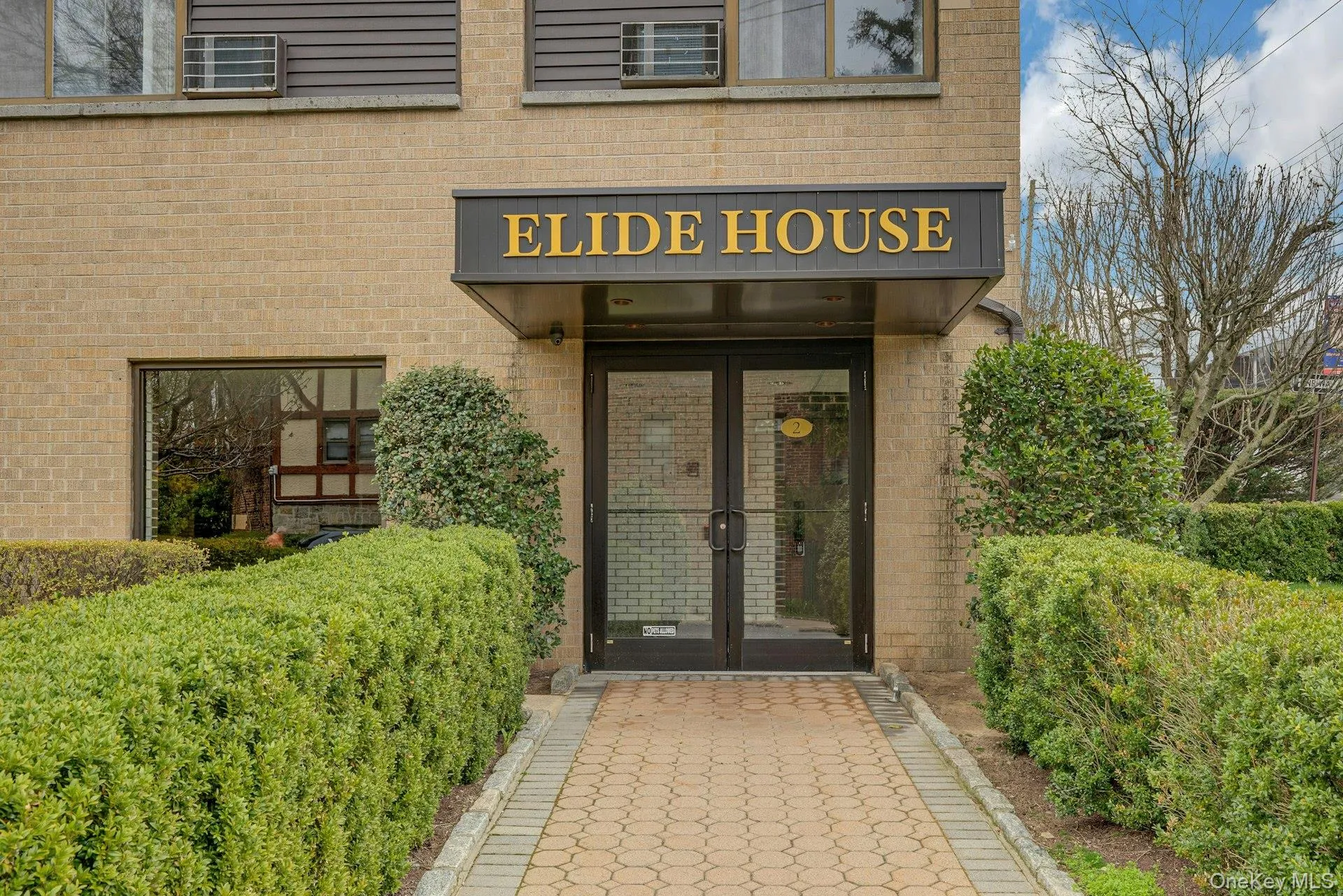 The building features a brick exterior with an awning over the main entrance The building features a brick exterior with an awning over the main entrance