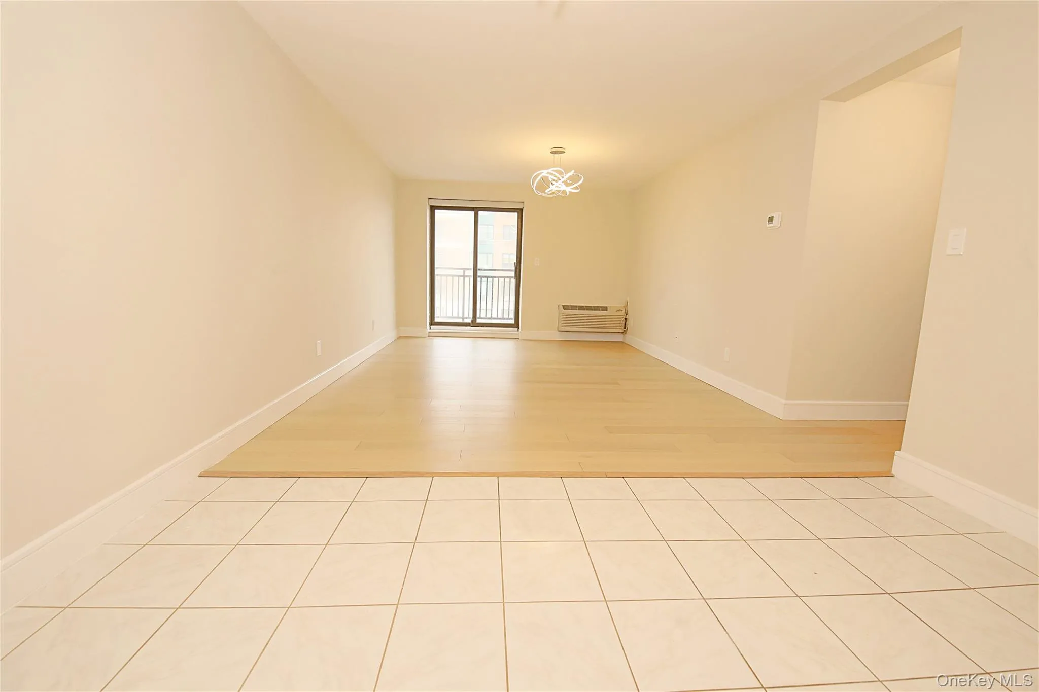 Spacious room with living room/dining area a neutral color palette, featuring a combination of tiled and light wood flooring with sliders to an ocean view terrace Spacious room with living room/dining area a neutral color palette, featuring a combination of tiled and light wood flooring with sliders to an ocean view terrace