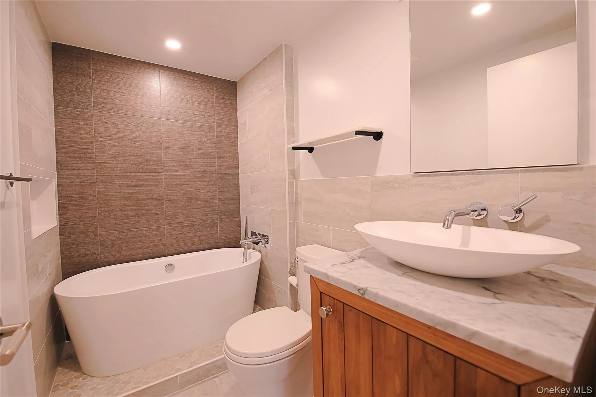 The bathroom features a freestanding soaking bathtub, a vanity with a white marble countertop, and a vessel sink The bathroom features a freestanding soaking bathtub, a vanity with a white marble countertop, and a vessel sink