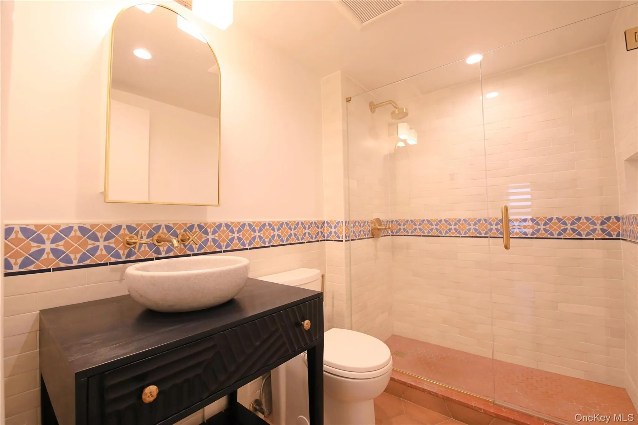 The bathroom features a vessel sink, a vanity with drawers, and a wall-mounted faucet The bathroom features a vessel sink, a vanity with drawers, and a wall-mounted faucet
