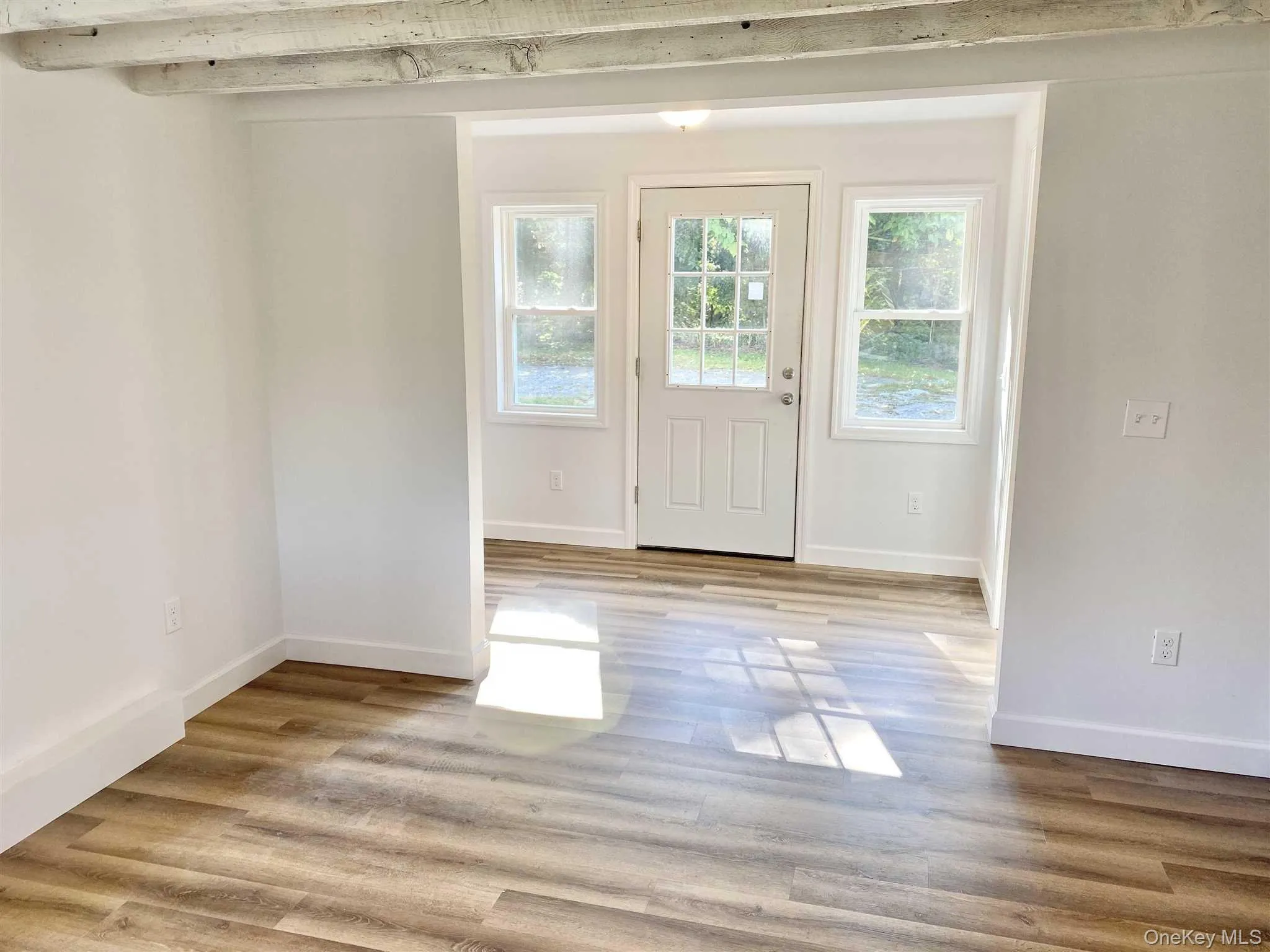 This inviting entryway and living area features wood-look flooring and a white door with glass panels This inviting entryway and living area features wood-look flooring and a white door with glass panels