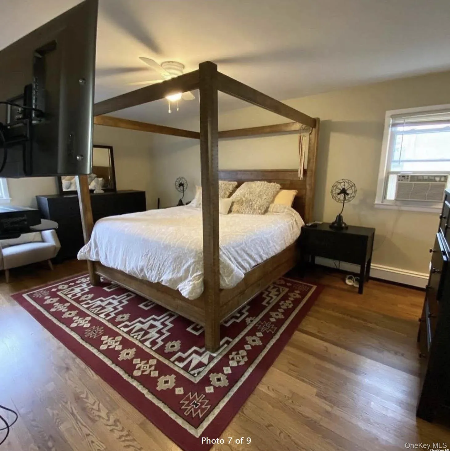Bedroom with wood finished floors, cooling unit, baseboards, and a baseboard radiator Bedroom with wood finished floors, cooling unit, baseboards, and a baseboard radiator