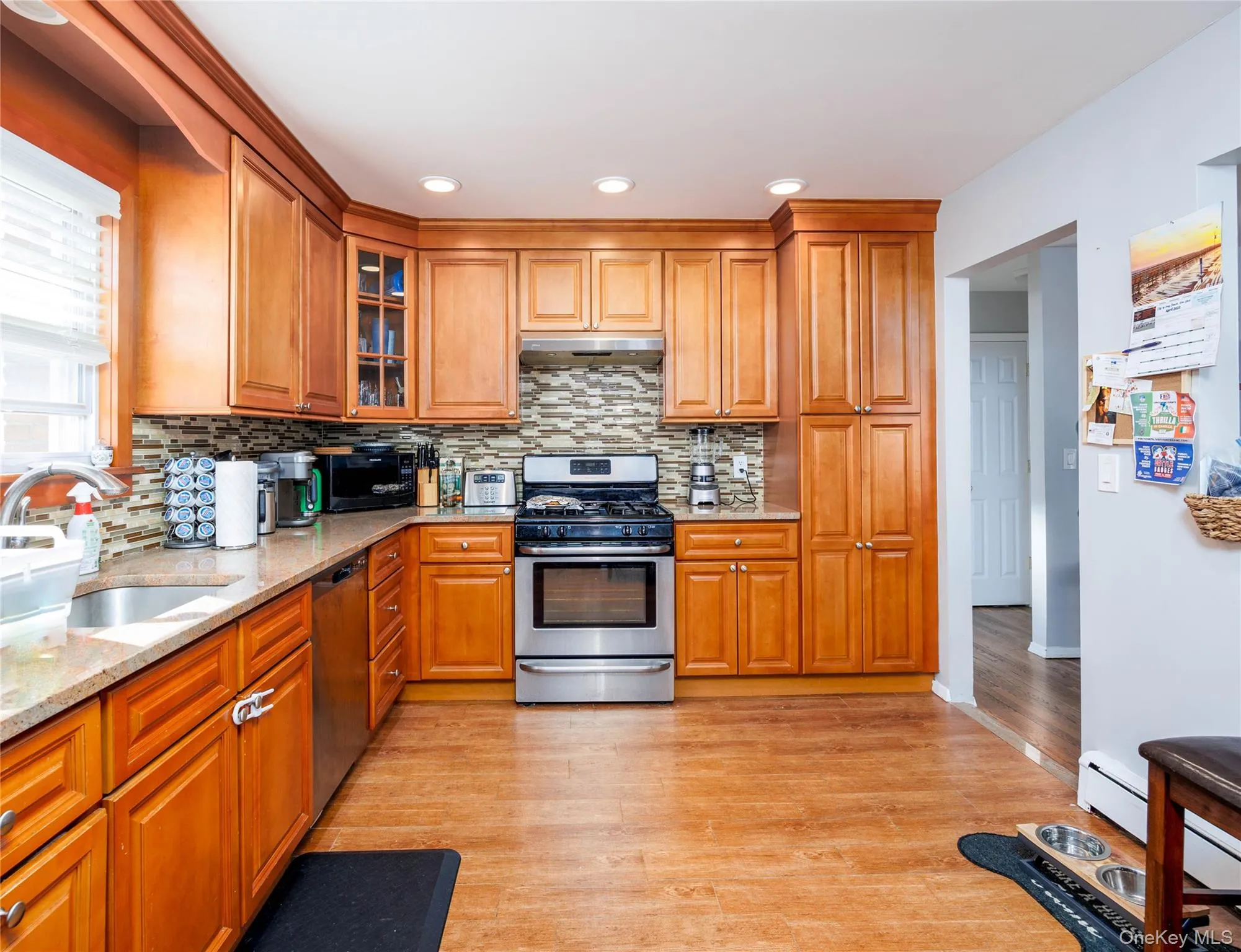 Kitchen featuring appliances with stainless steel finishes, brown cabinets, and recessed lighting Kitchen featuring appliances with stainless steel finishes, brown cabinets, and recessed lighting