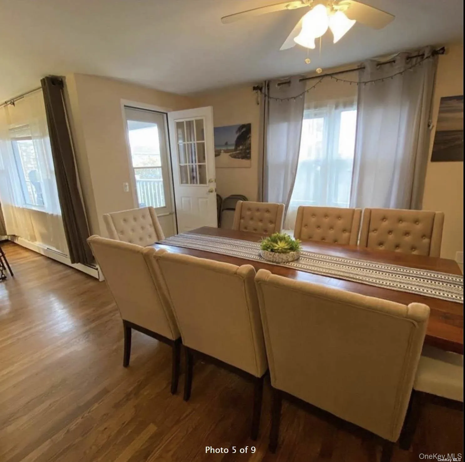 Dining room featuring wood finished floors, healthy amount of natural light, a ceiling fan, and baseboard heating Dining room featuring wood finished floors, healthy amount of natural light, a ceiling fan, and baseboard heating